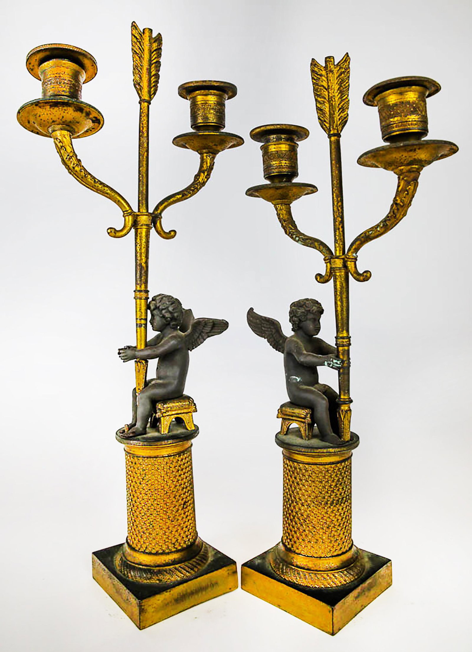 Pair of 19th C. Cherub Candelabra: Pair of 19th century cherub candelabra, each holding arrows. [15 1/2" H x 6 1/2" W x 3" D].