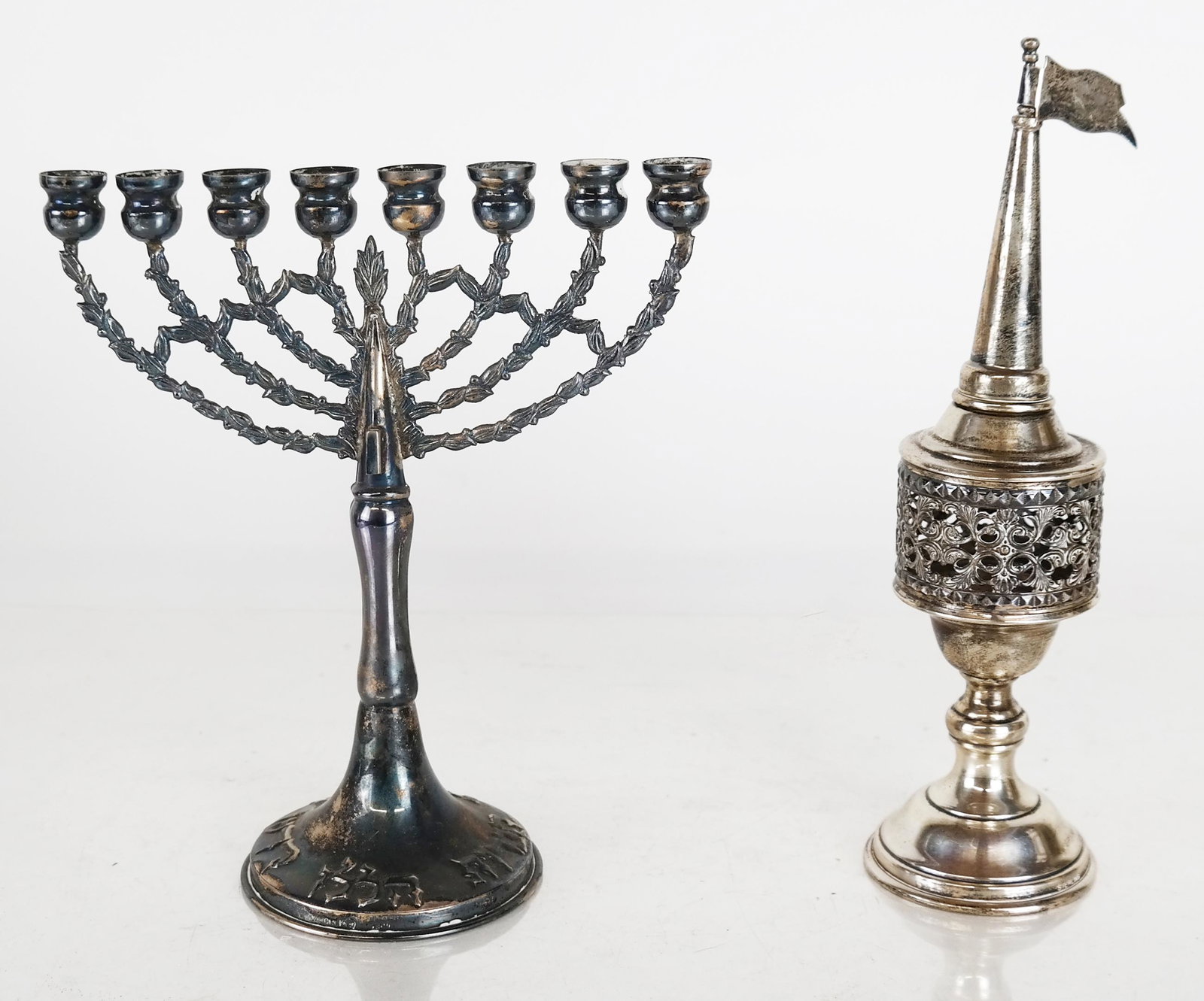 Sterling Silver & Silver Plate Judaica: Sterling silver bessamim (spice tower) [7 1/2" H x 2" Diam.] and silver plate menorah [6 1/2" H x 5 3/4' W x 2 1/2" D]. Bessamim: 2.145 ozt.