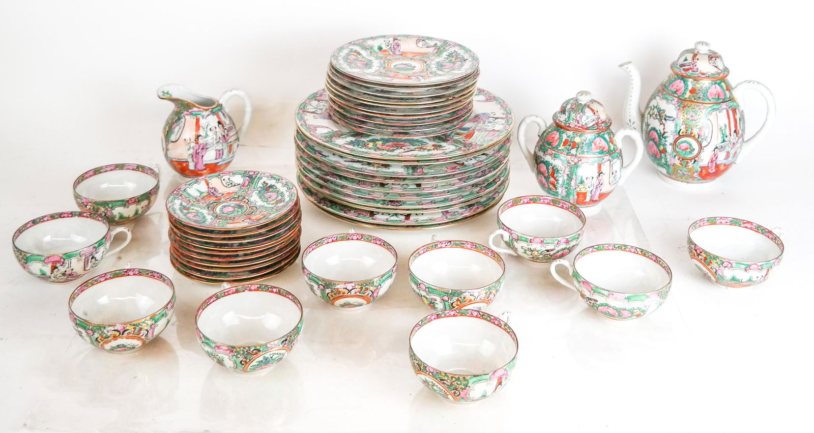 Rose Medallion Dinnerware - 33 Pcs.: Rose medallion dinnerware, including 10 dinner plates [10" Diam.], 10 saucers, 10 tea cups, tea pot [8" H], sugar with cover and creamer. In overall good condition.