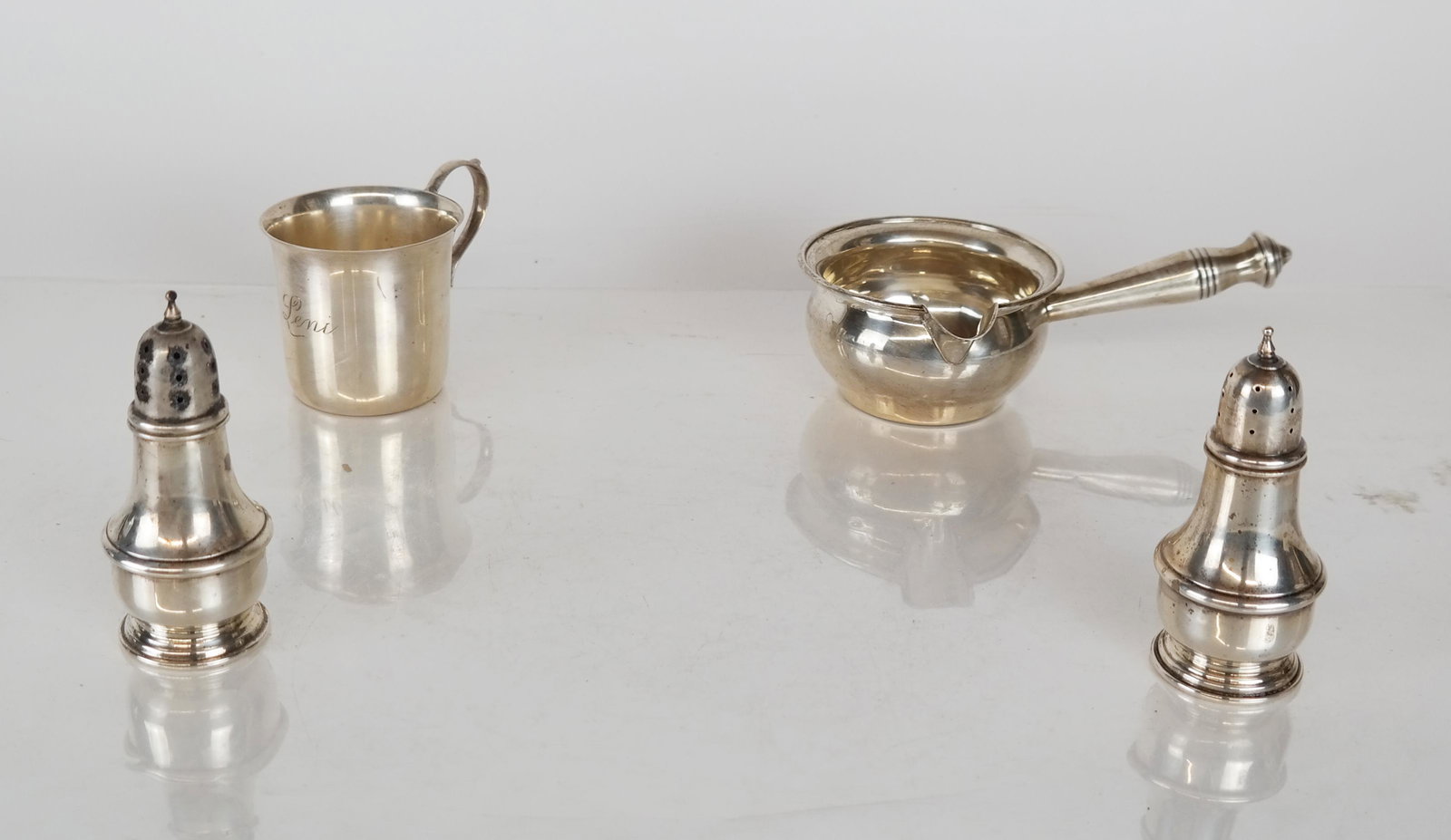 Sterling Silver Child's Cup, Pourer, Salt Shakers: Sterling silver child's cup [2 3/4" H x 4" W x 2 3/4" D] and sauce pourer [2" H x 7" W x 4 1/8" D] together with two salt shakers (one weighted) by Lenox Silver. 13.71 ozt. weighable silver.