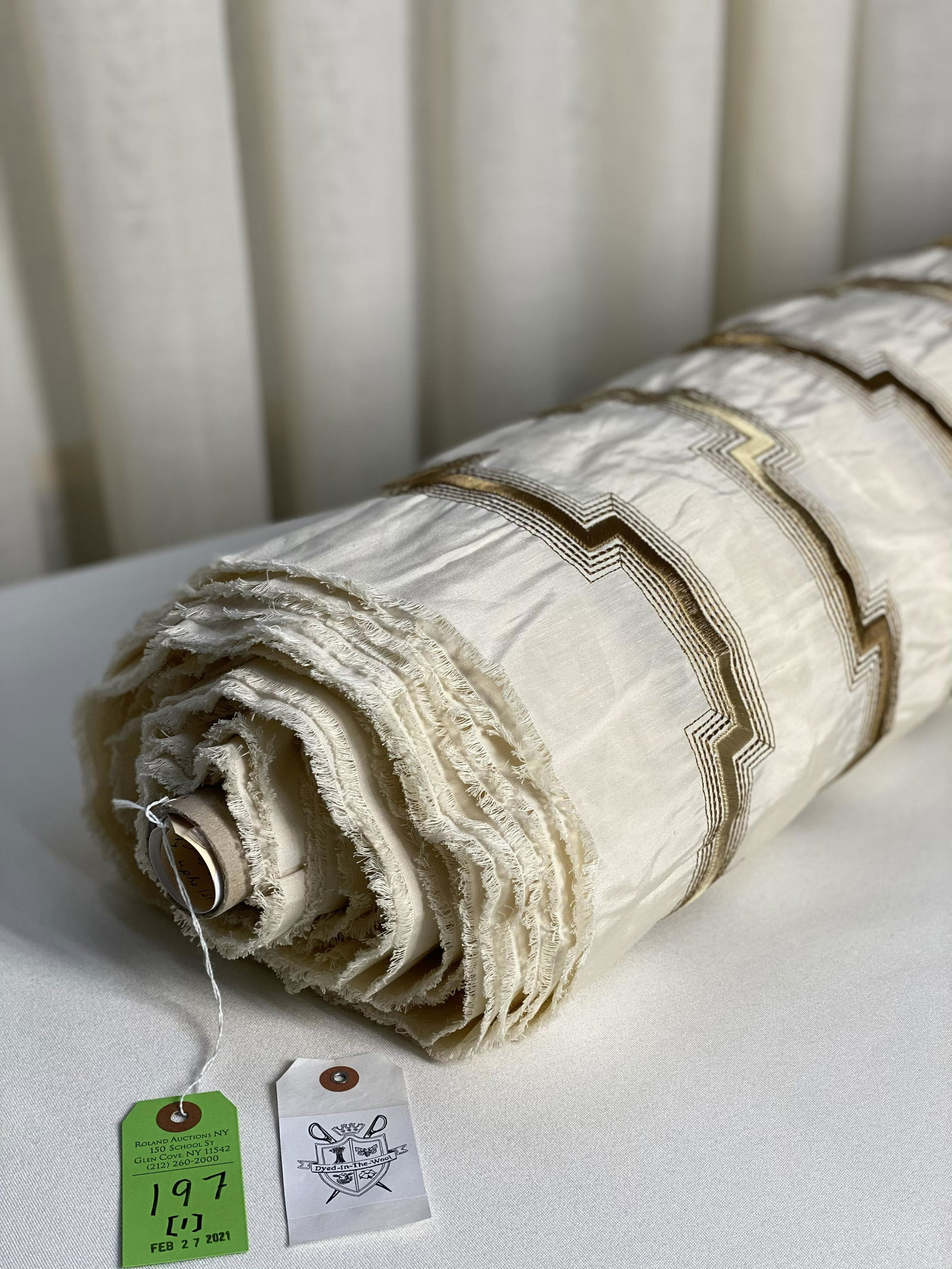 An Embroidered Geometric Fabric: 22 yards of a stunning viscose embroidery on a silk and linen ground. The tan and mocha on a creamy off-white stepped warp stripe has design repeats of 15" vertical by 8 1/2" horizontal and has an app