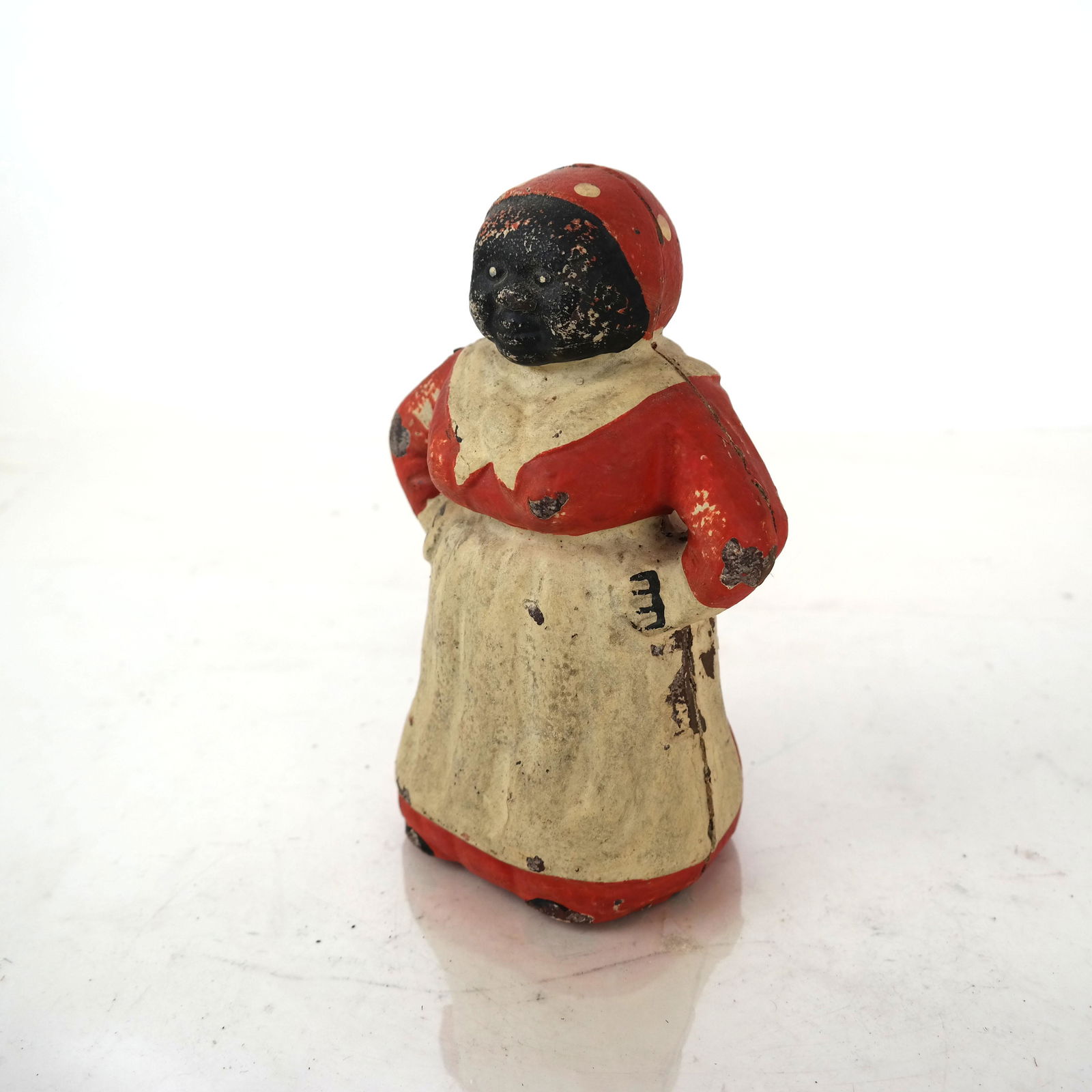 Antique "Mammie" Cast Iron Toy Bank: Painted cast iron bank in the form of a standing woman. Unmarked. [7 3/4"H x 3 3/4" W x 4" D]. Paint loss, soiling and wear consistent with age and use. Sold "as-is".