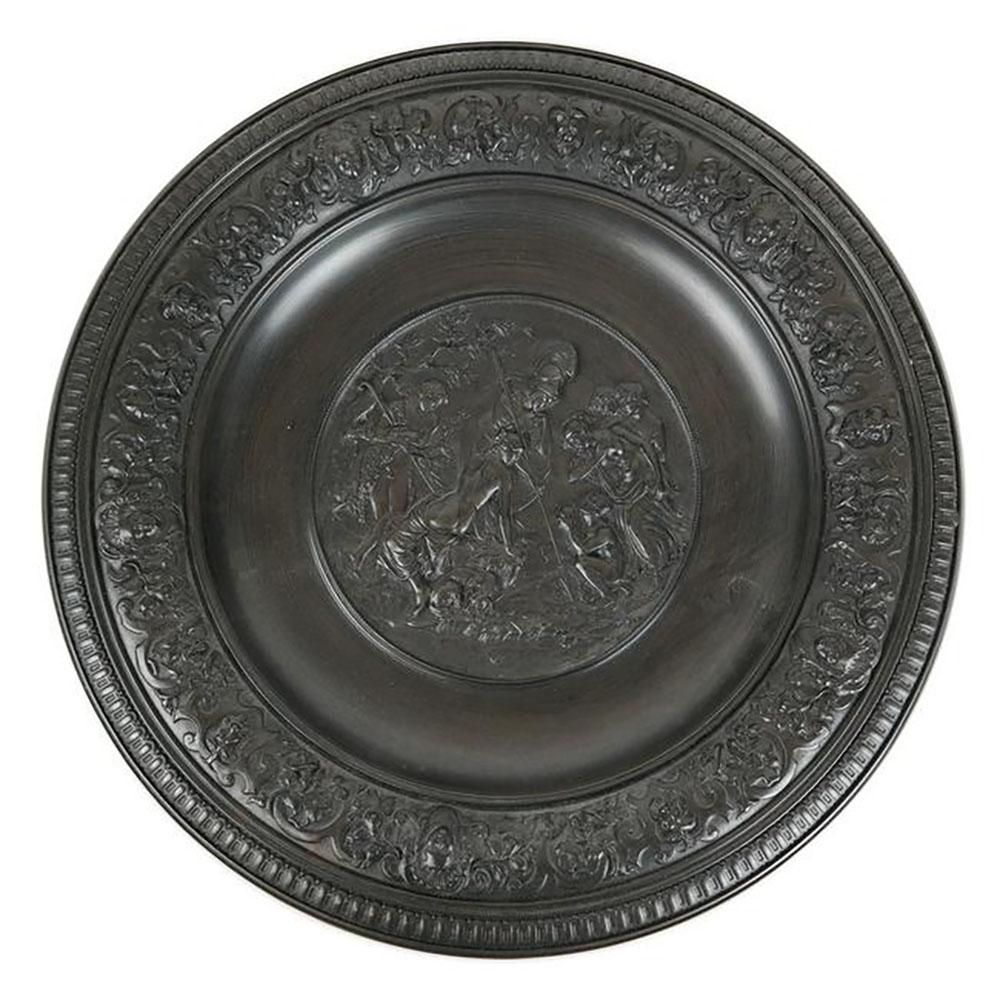 Allegorical Relief Iron Charger: Allegorical relief plaque of nude figures in a landscape. [1 1/4" H x 17 1/2" Diam.].