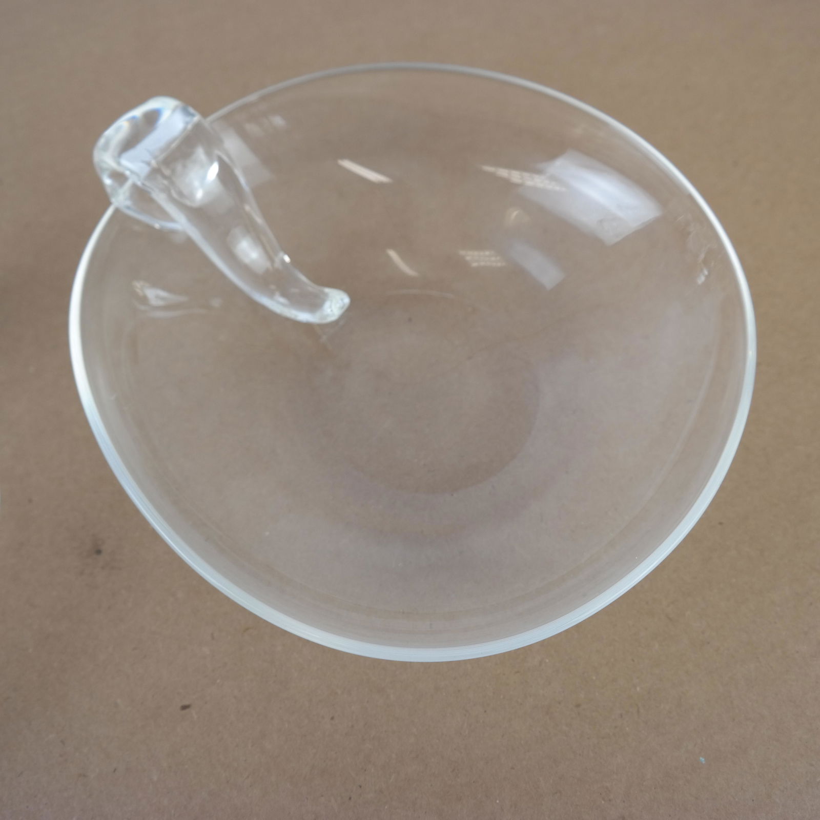 Two Steuben Handled Bowls: Two Steuben bowls, one with snail-form handle in ovoid shape, the other with scroll handle. [Larger: 3"H x 9" Diam.].