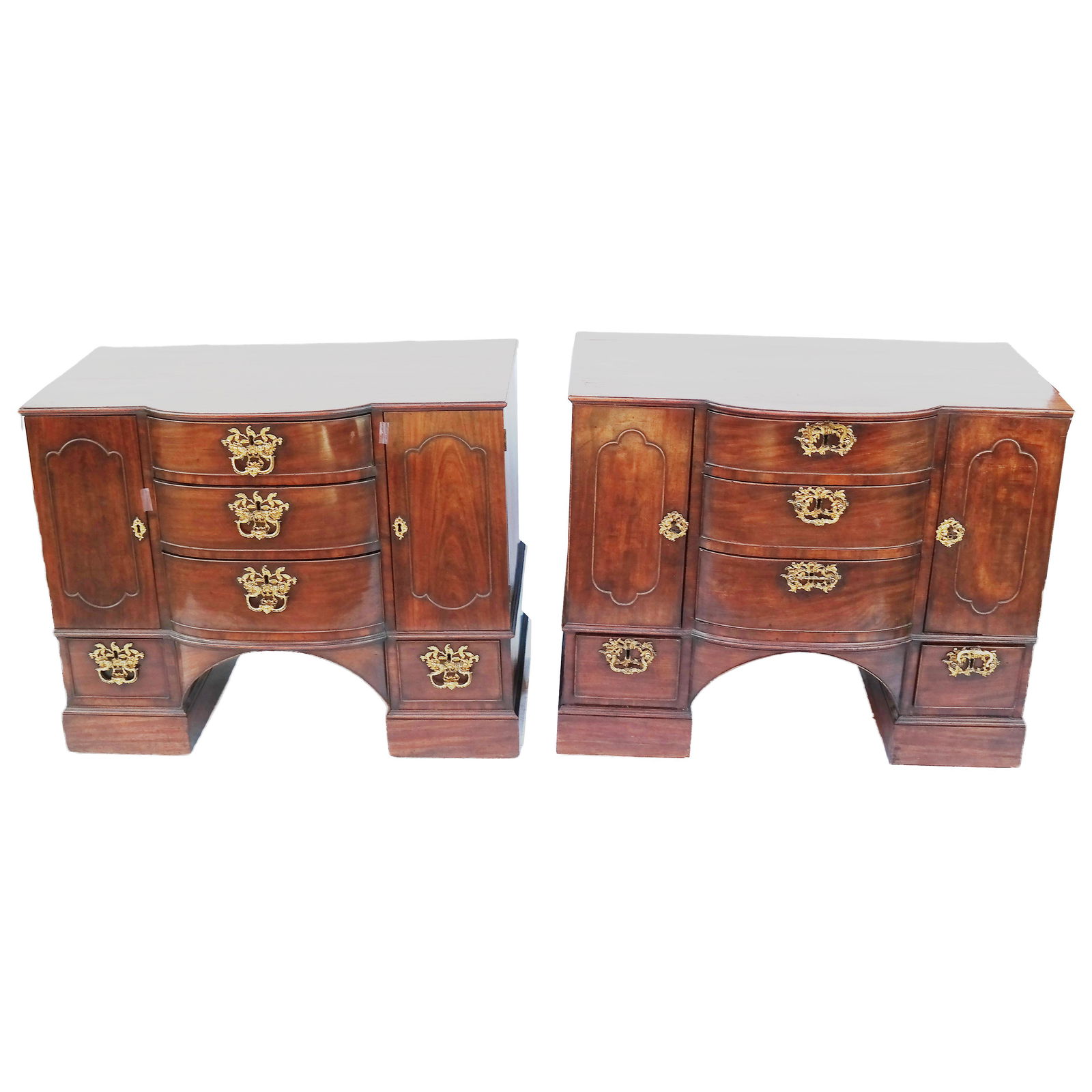 Matched Pair George III Mahogany Commodes: Well-matched pair of George III mahogany pier commodes, circa 1760. In the manner of Thomas Chippendale, the rectangular tops with convex center sections, above three centrally arranged conformingly s