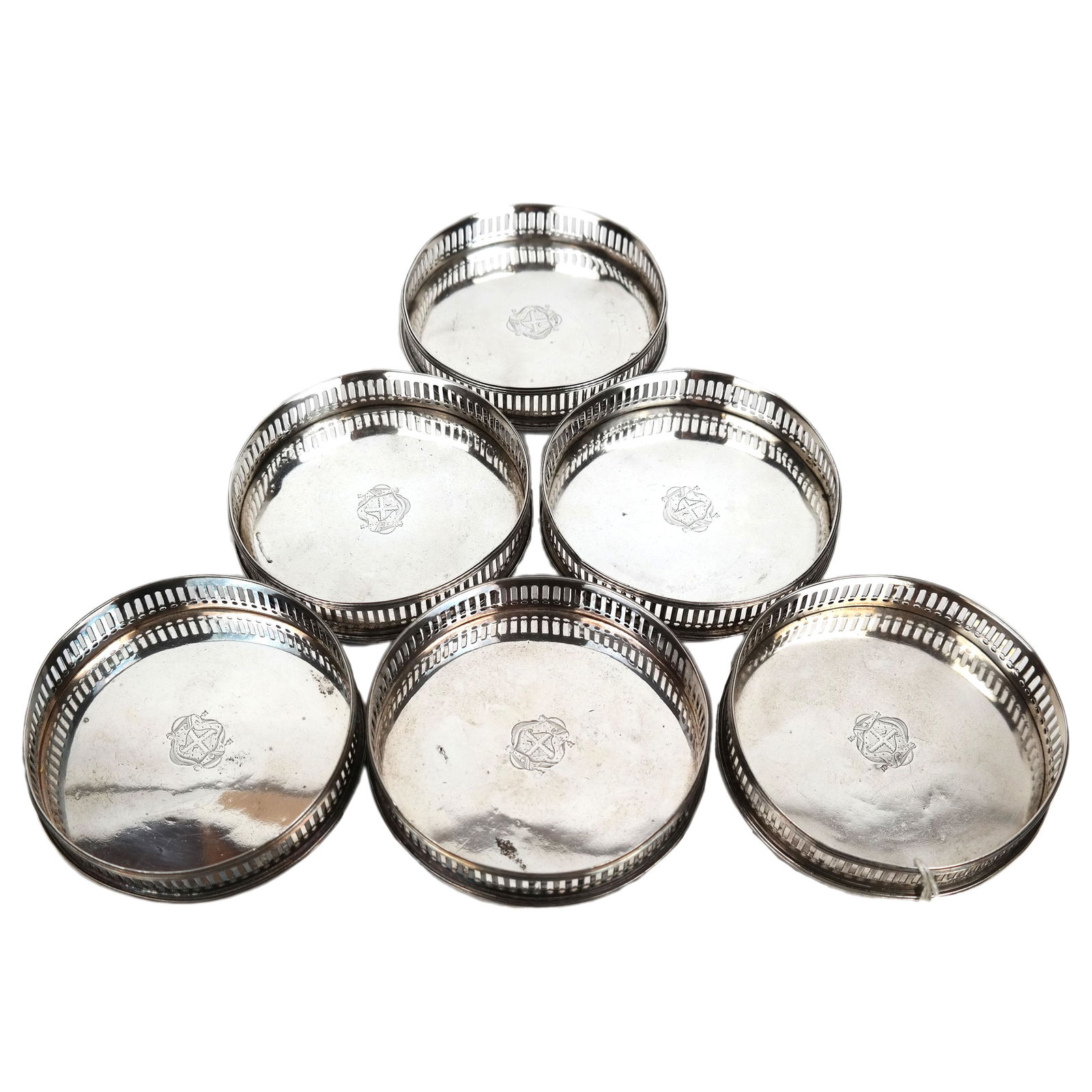 Set of Six George III Silver Wine Coasters: A rare set of six George III silver wine coasters, by William Plummer, London, 1788, having pierced sides, the centers engraved with the coat-of-arms of Leigh of Ridware, Co. Stafford. Each coaster is