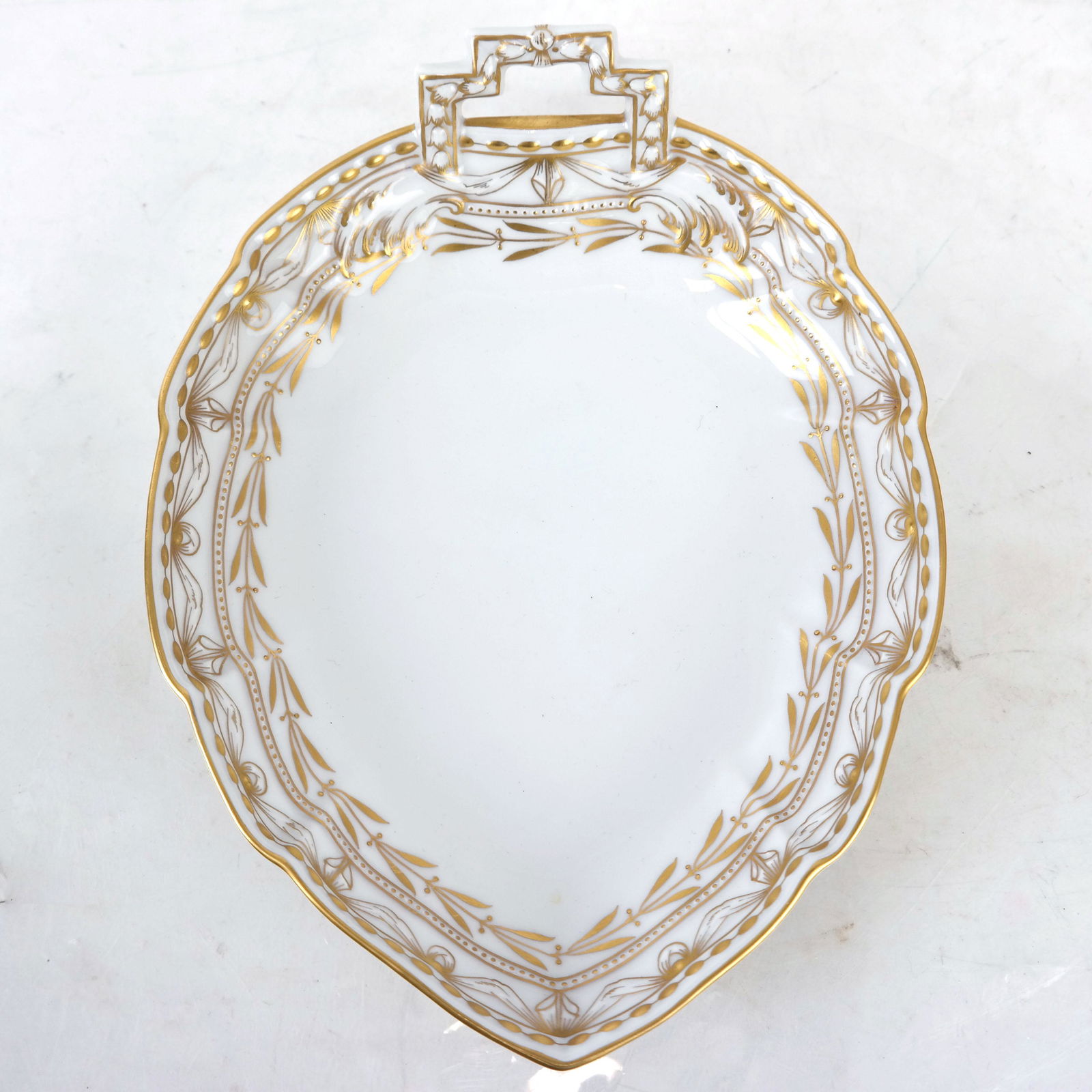 KPM Gilt Trim Dish: KPM gilt trim dish, leaf shaped with square handle. [2" H x 9 1/2" W x 7" D]. In good condition.