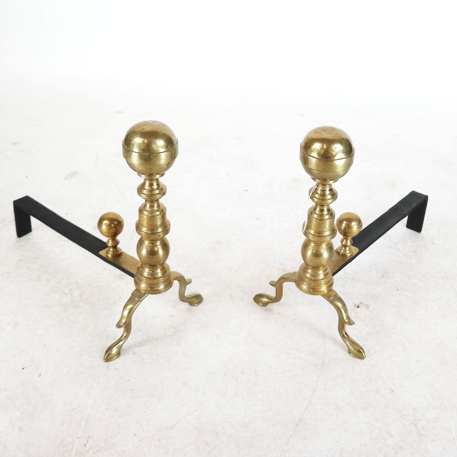 Pair of Polished Brass Andirons: Pair of polished brass andirons. [17" H x 10" W x 18" D]. Both with dents in tops.
