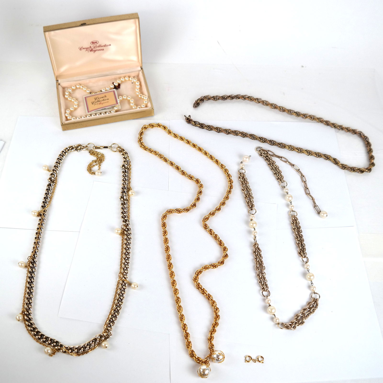 Costume Chains and Trifari Pearl Necklace: Trifari Crown Collection pearl necklace (18" long), in a box, together with 4 gold tone and faux pearl chain necklaces / belts.