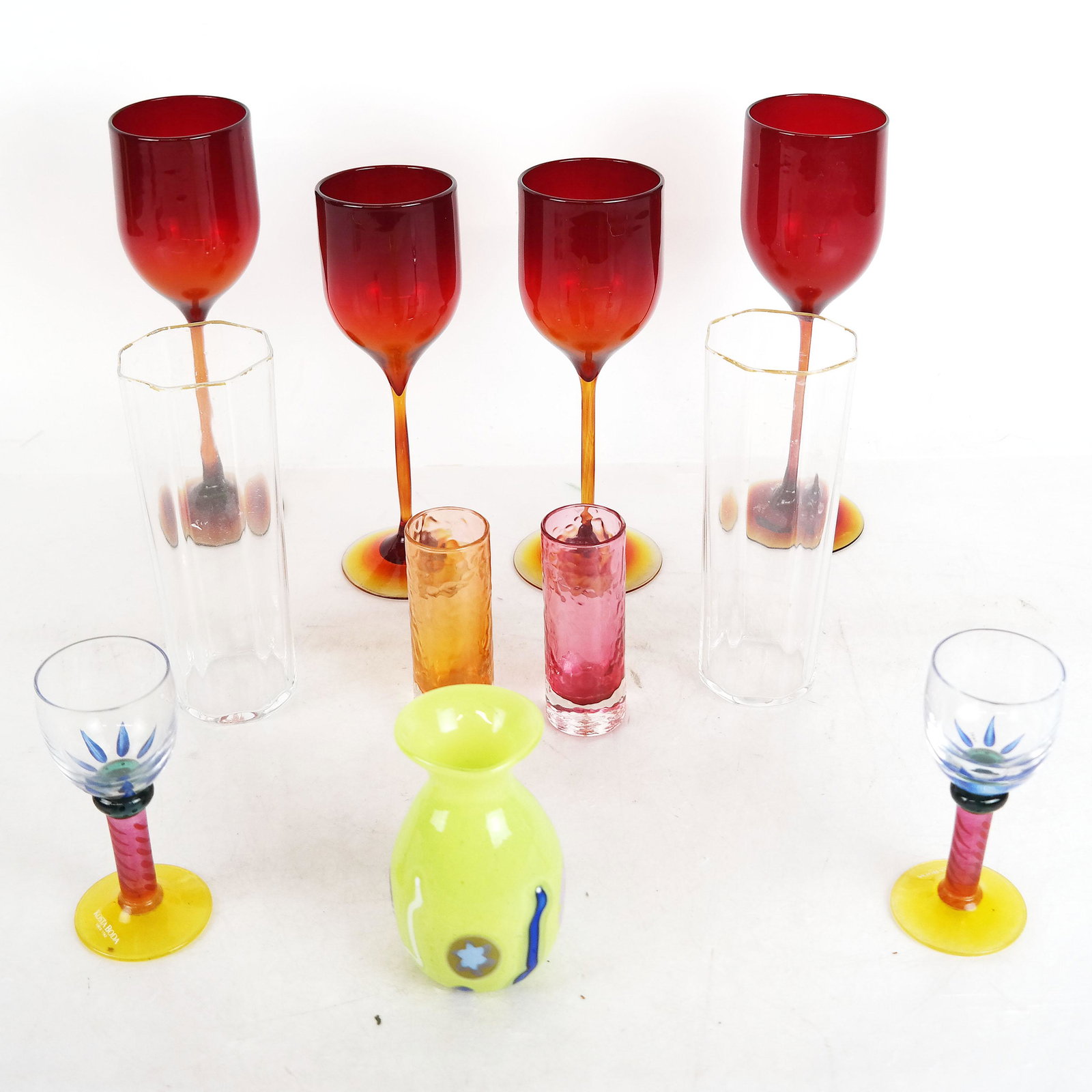 Lot of Murano Glassware and Others (14): Lot includes Murano glassware, 2 Kosta Boda cordials, 4 ruby glass wine glasses, signed illegibly, and more. [Glasses: 8 3/4" H; Dish: 1 1/2" H x 7 1/4" W x 7 1/4" D]. In good condition; no chips.