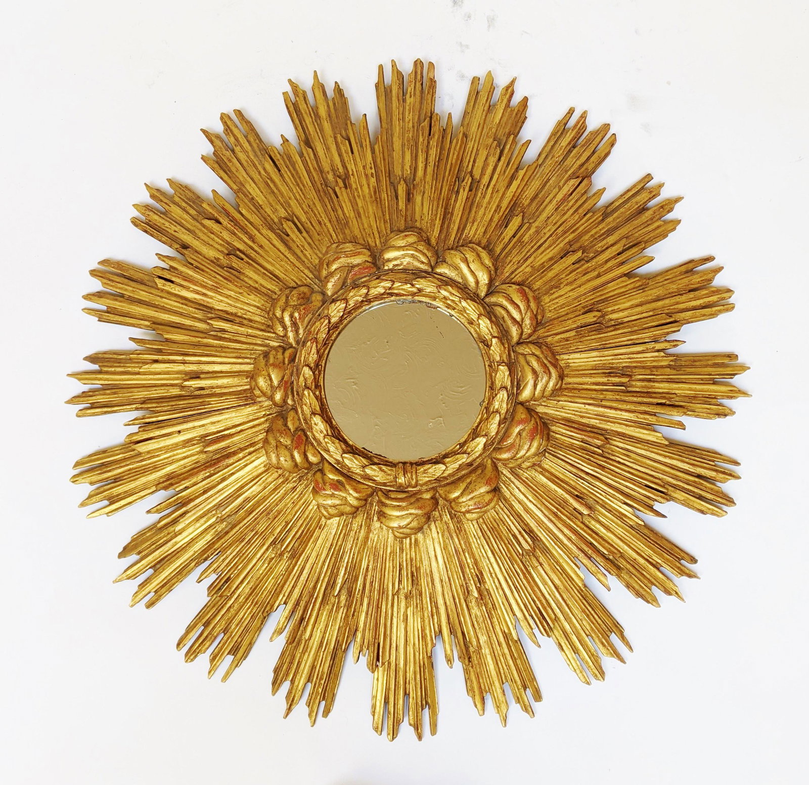 Gilt Wood Sunburst Mirror: Wood hand-carved having a burst of sun rays set around acanthus leaf and crown bezel, with inset mirror. [33" Diam.].