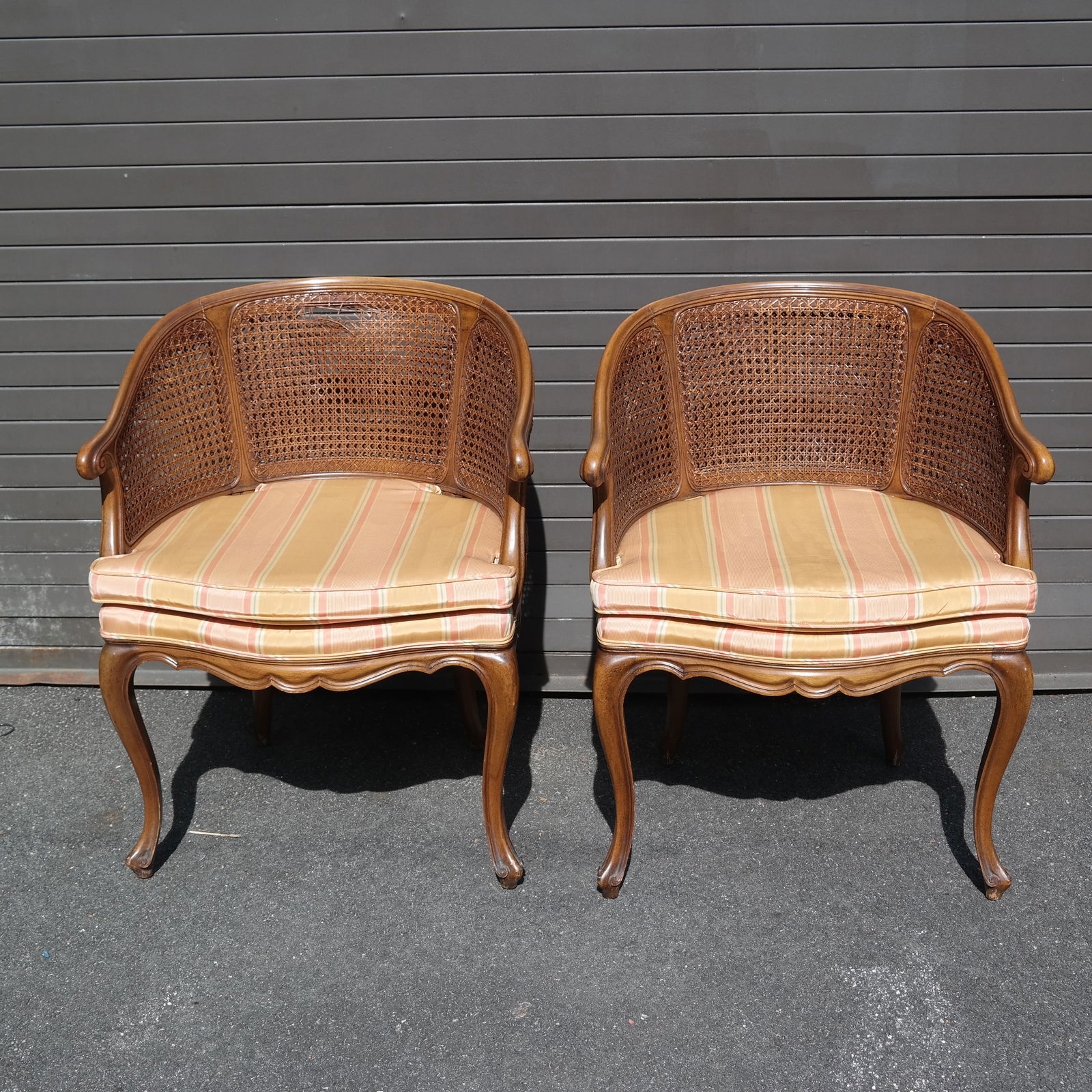 Pair of French Roundabout Chairs: Pair of caned chairs with pad seats. [32" H x 26" W x 24" D]. Cane as-is.