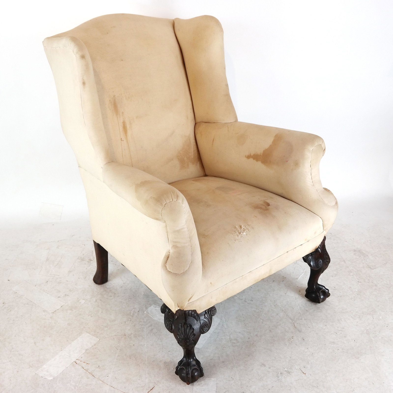 Chippendale-Style Mahogany Wing Chair: Finely carved mahogany wing chair, with ball and claw feet, upholstered in muslin, circa 1880. [42" H x 31' W x 31" D].