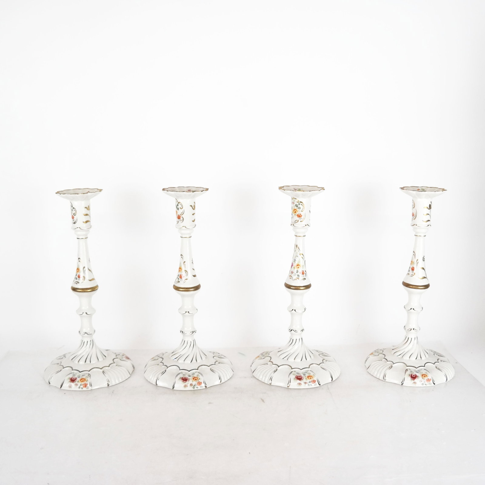 Four Chelsea House, Italy Candlesticks: Set of four decorated porcelain candlesticks, Chelsea House, Port Royal. Provenance: From the Upper East Side estate of a prominent NYC interior decorator. [12" H x 5 1/2" Diam. (base)]. All in good c