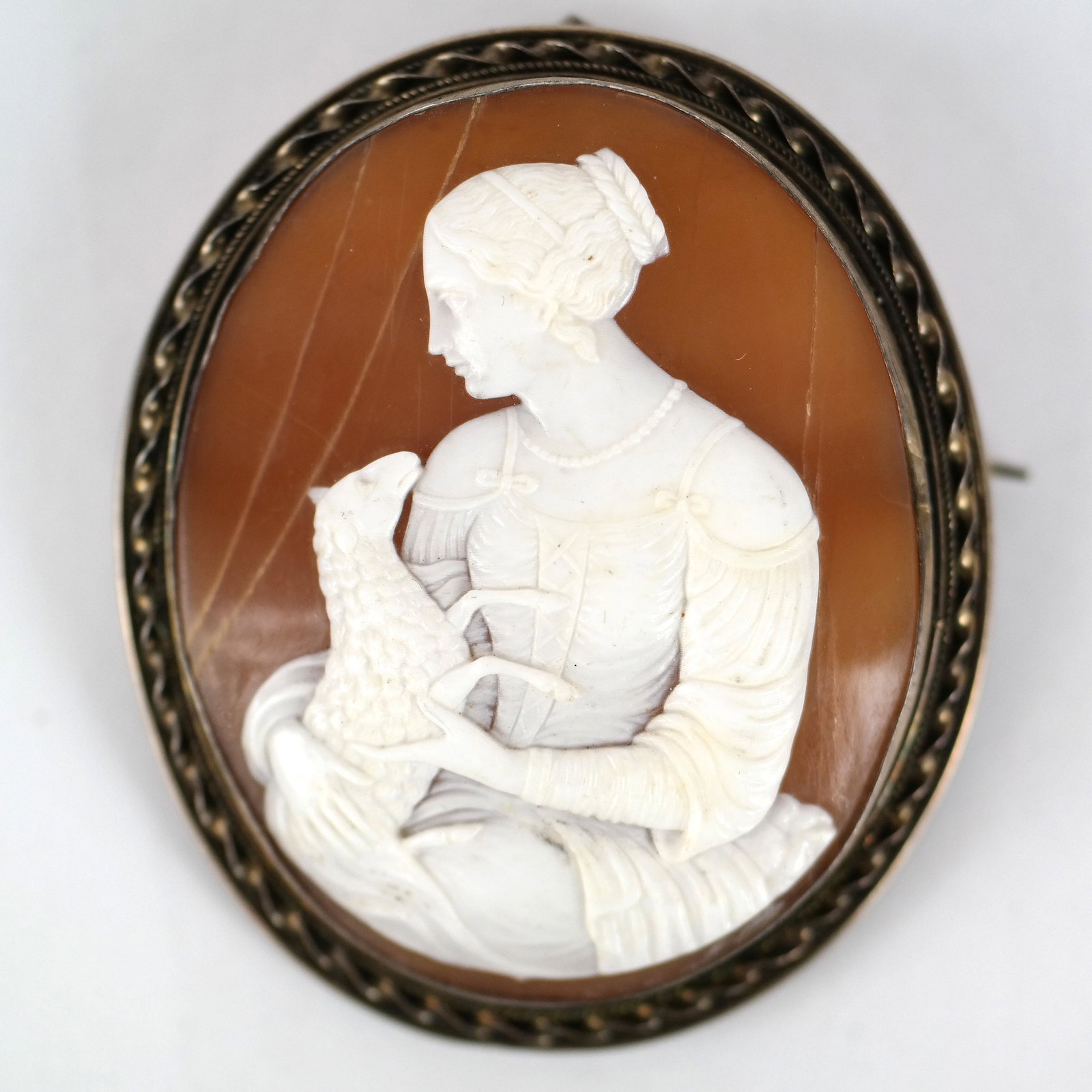 Antique European Intaglio Cameo Brooch: 19th-20th century European intaglio cameo pin, carved with a woman holding a lamb. [2 1/8" H x 1 3/4" W]. Cameo in good condition; setting with age-appropriate wear.