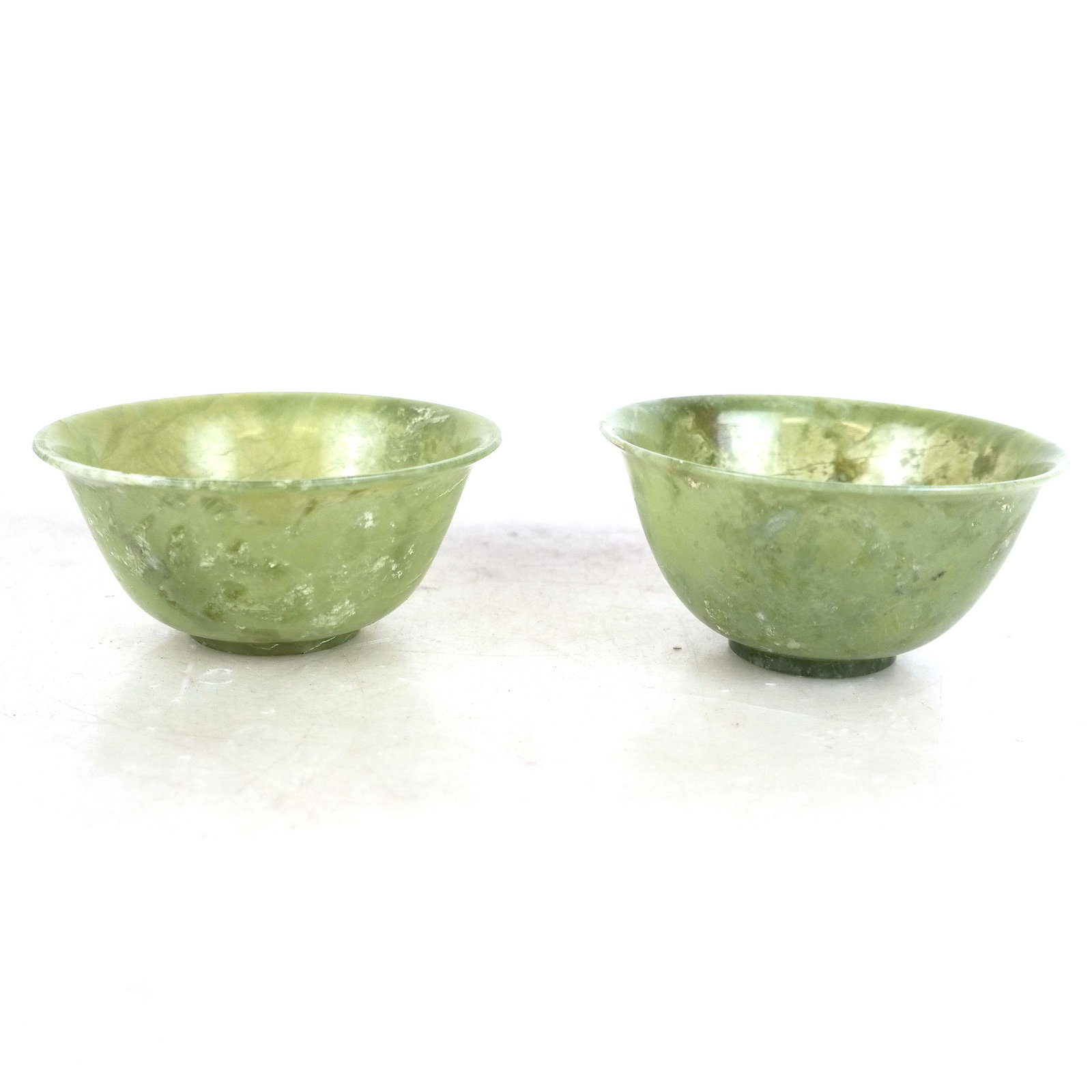 Two Chinese Green Jade Bowls: Two Chinese green jade bowls. Provenance: From the Estate of Congressman Lester L. Wolff. [1 3/4" H x 4" Diam.].