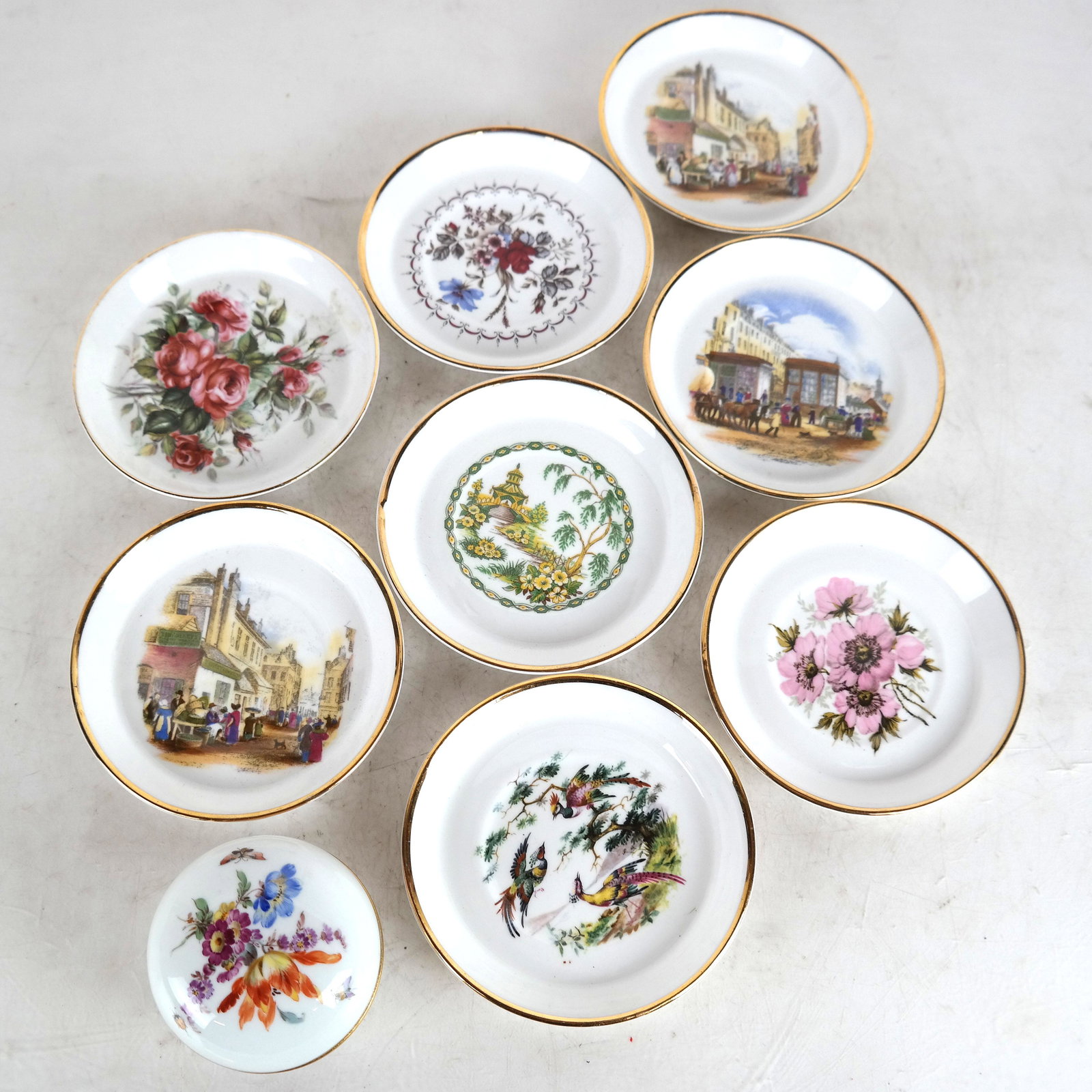 Meissen Porcelain Covered Dish & 8 China Dishes: Lot includes a Meissen floral decorated and gilt porcelain covered jar [2" H x 2 3/4" Diam.] together with 8 Royal Sutherland, Staffordshire fine bone chain saucers / plates [4 5/8" Diam.], each with 