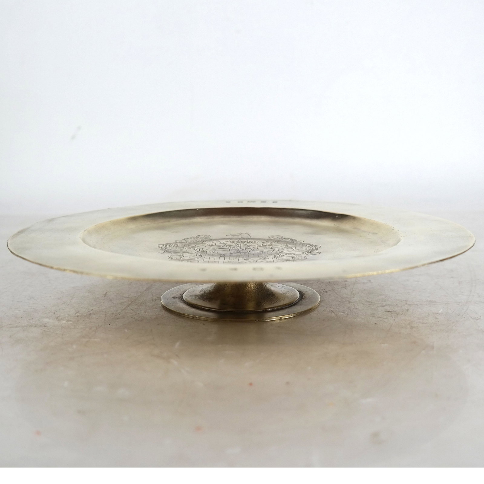 English Silver Vermeil Tazza: Round tazza with incised coat of arms center, on post base. Hallmarked F St. G. 25 ozt. [1 1/2" H x 10" Diam.].