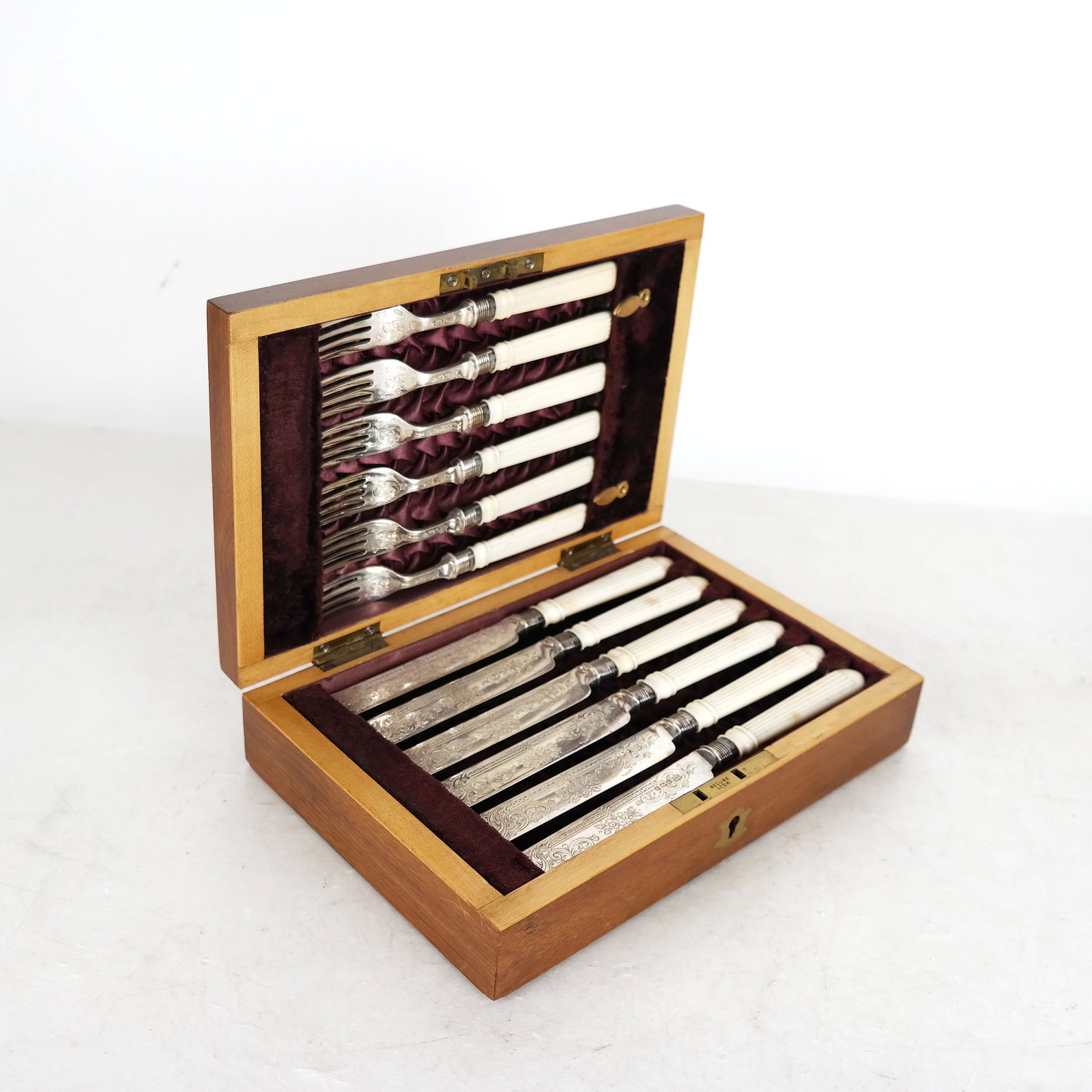 Sheffield Silver Bone-Handled Cutlery Set in Box: Cooper Brothers, Sheffield, England, 1892, set of 12 bone-handled knives and forks (6 of each), in a bespoke velvet-lined box. [Knives: 8" L; Box: 2 1/2" H x 9 1/8" W x 6 1/8" D]. In good condition.