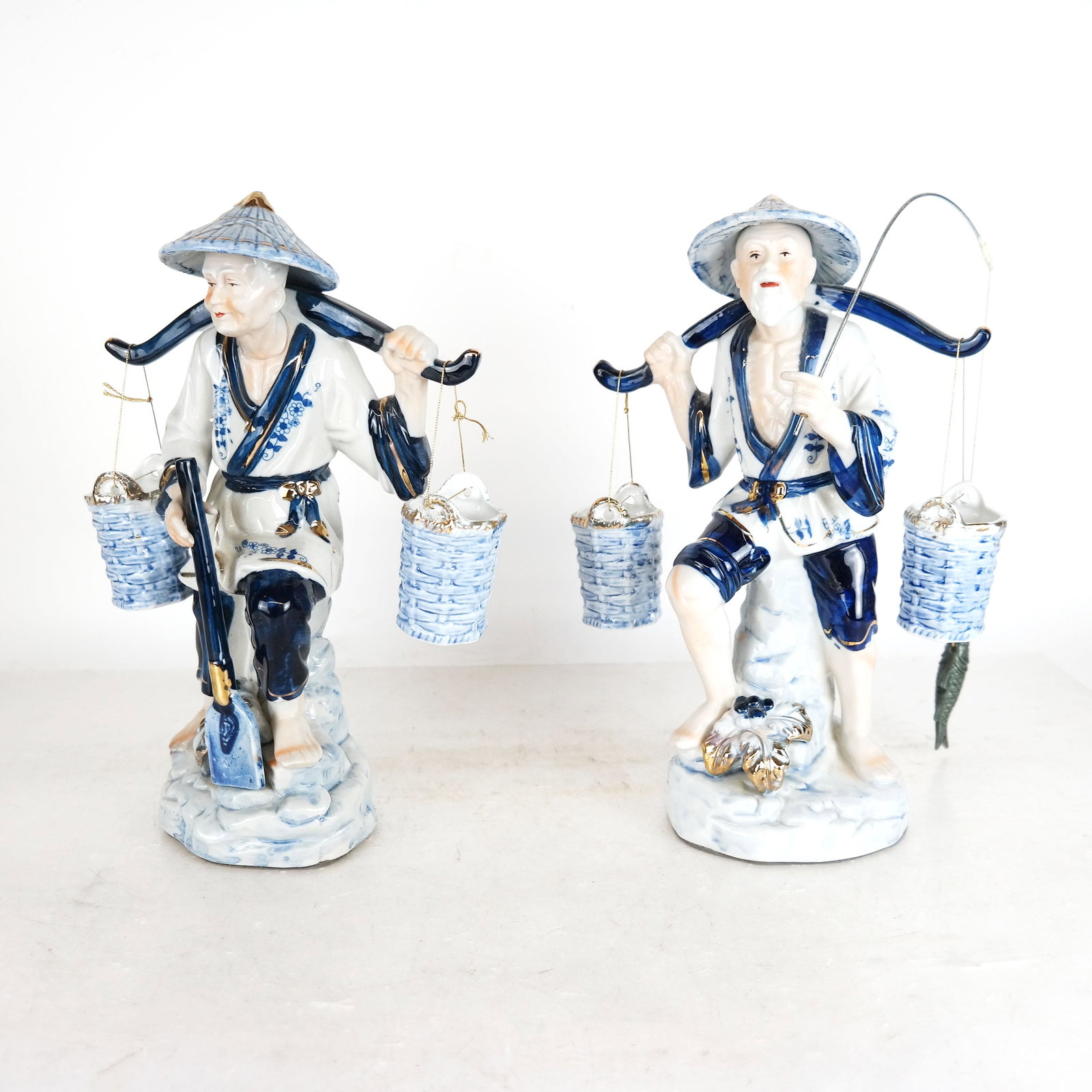 Chinese Blue & White Porcelain Fisherman Couple: Porcelain Chinese Fisherman Couple cobalt blue and white figurine statues, made in Taiwan Republic of China. [13" H x 9" W x 4" D]. In good condition.