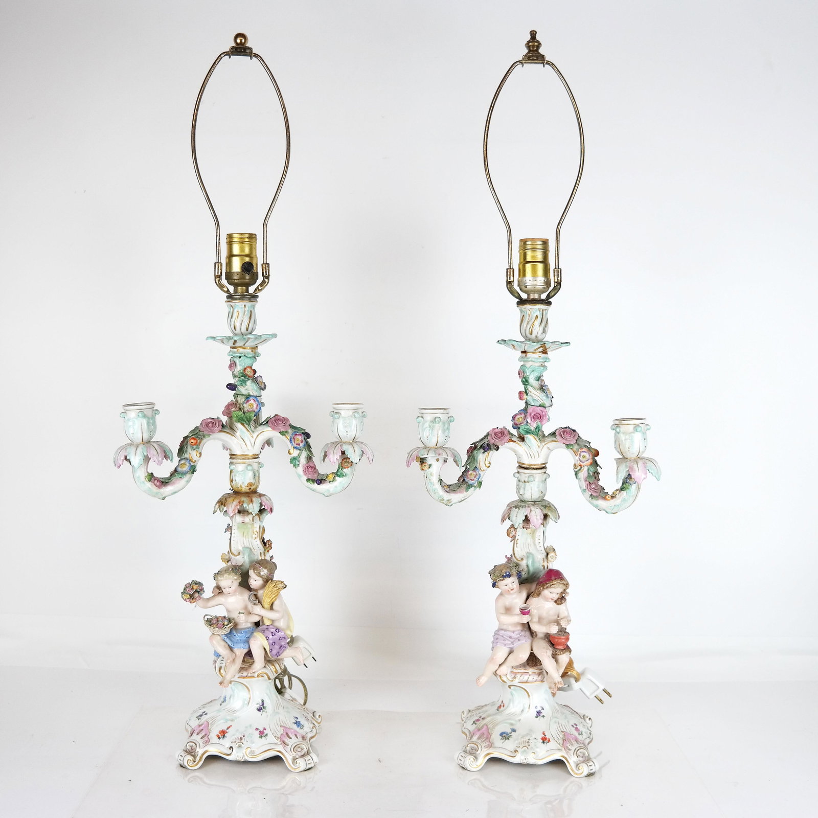 Pair of Meissen Candelabra, as Lamps: Pair of Meissen candelabra, center post only as a lamp, depicting children on posts of flowering scrolls. [19 1/2" H; Overall: 31" H]. As-is, and one missing arm.