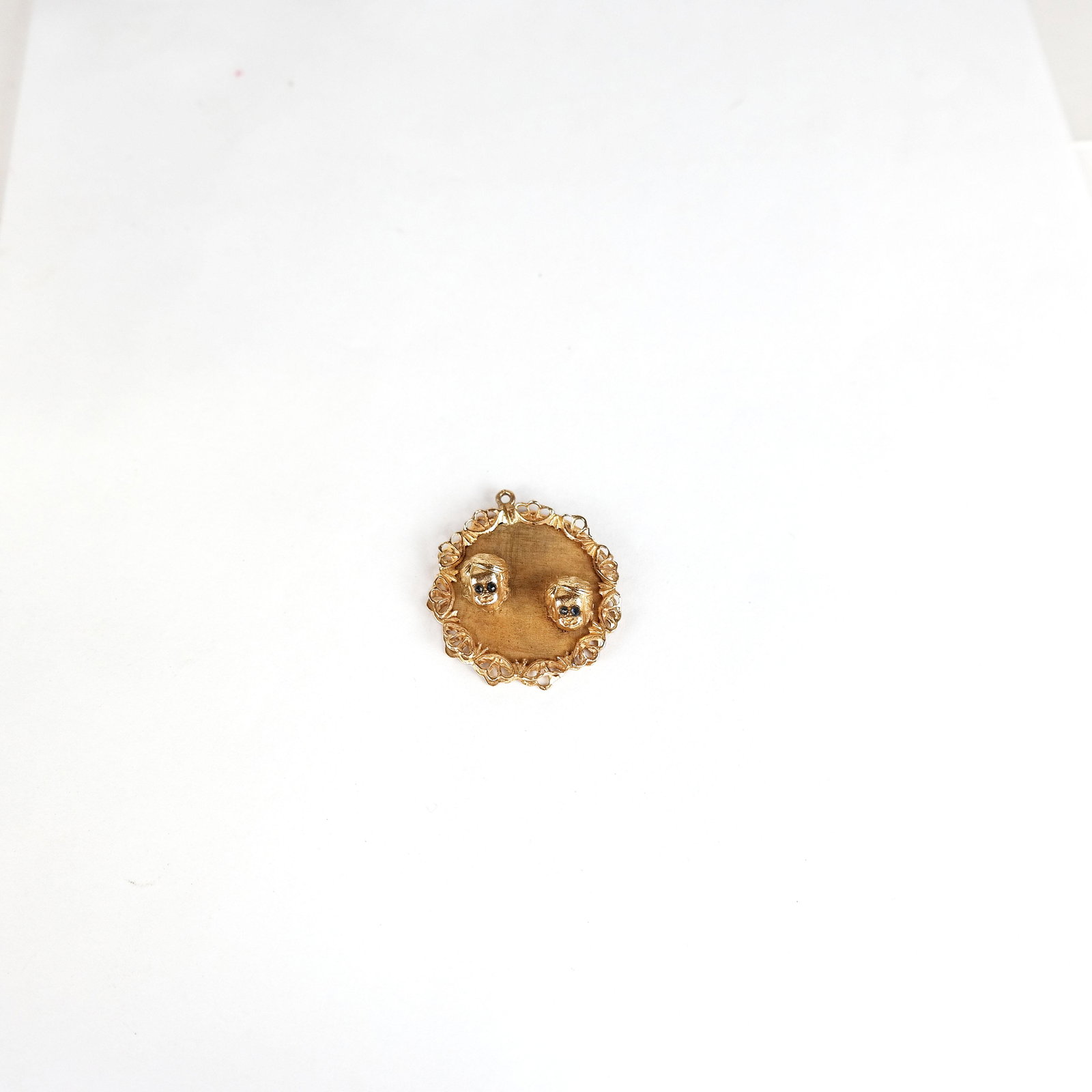 14K Gold Twin Boys Charm / Pendant: 14K yellow gold twin boys charm / pendant, engraved on th back, the eyes inlaid with blue stones. 1 1/4" Diam. 5.1 dwt. inclusive.