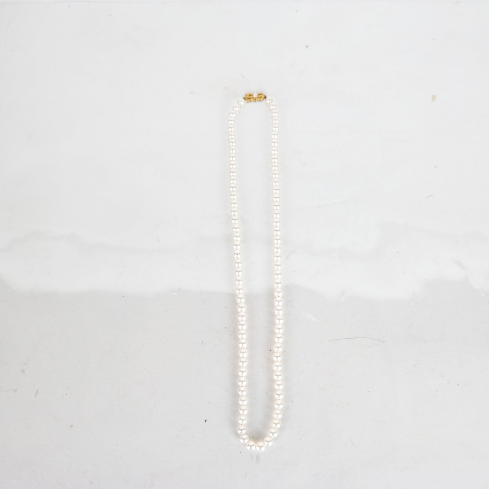 Mikimoto 24" Cultured 7mm Pearl Necklace: 24" pearl necklace with 18K yellow gold clasp, marked "750" and "M". In good condition.