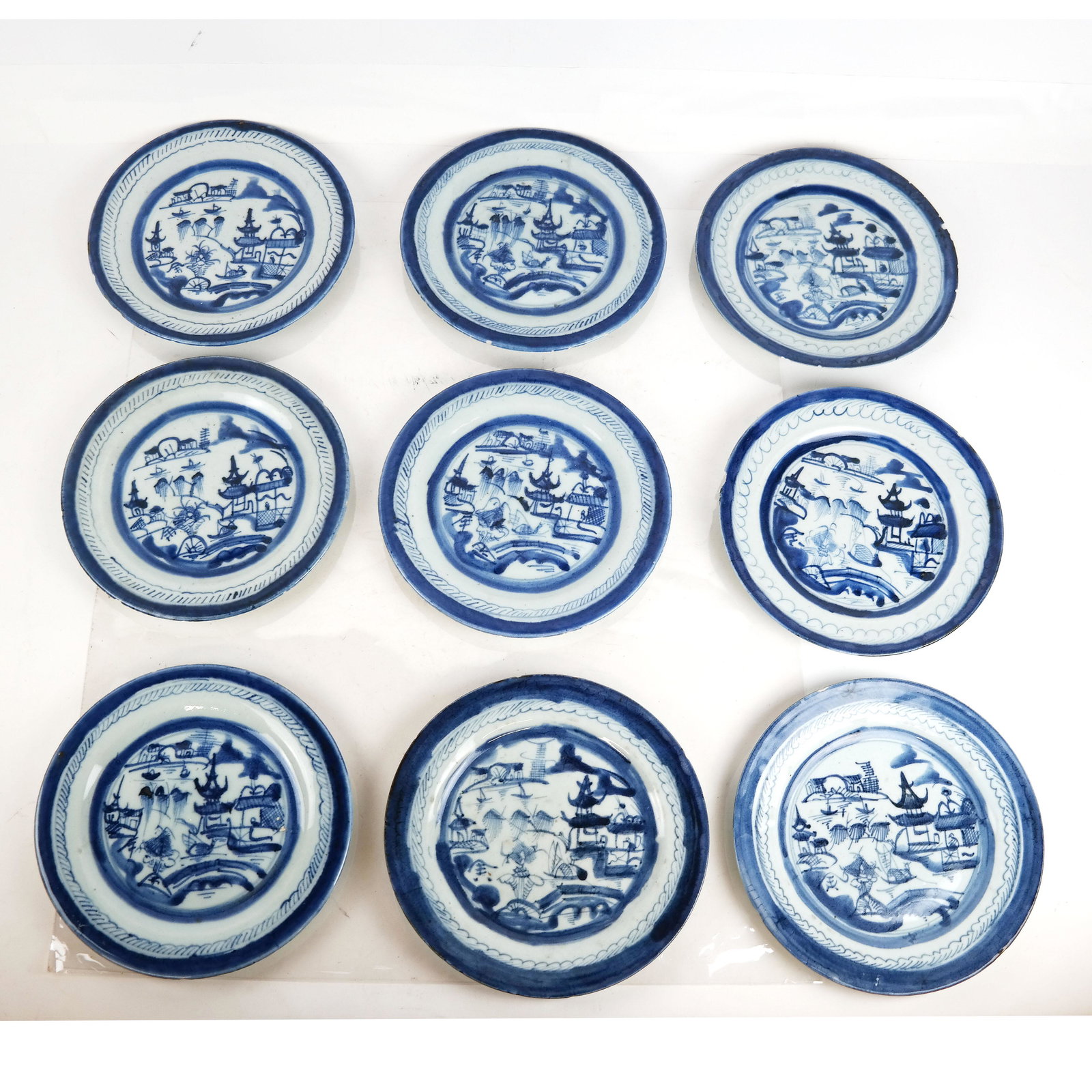 Group of 9 Blue & White Plates: Group of 9 flow blue and white plates. [8 1/2" DIam.]. All with chips.