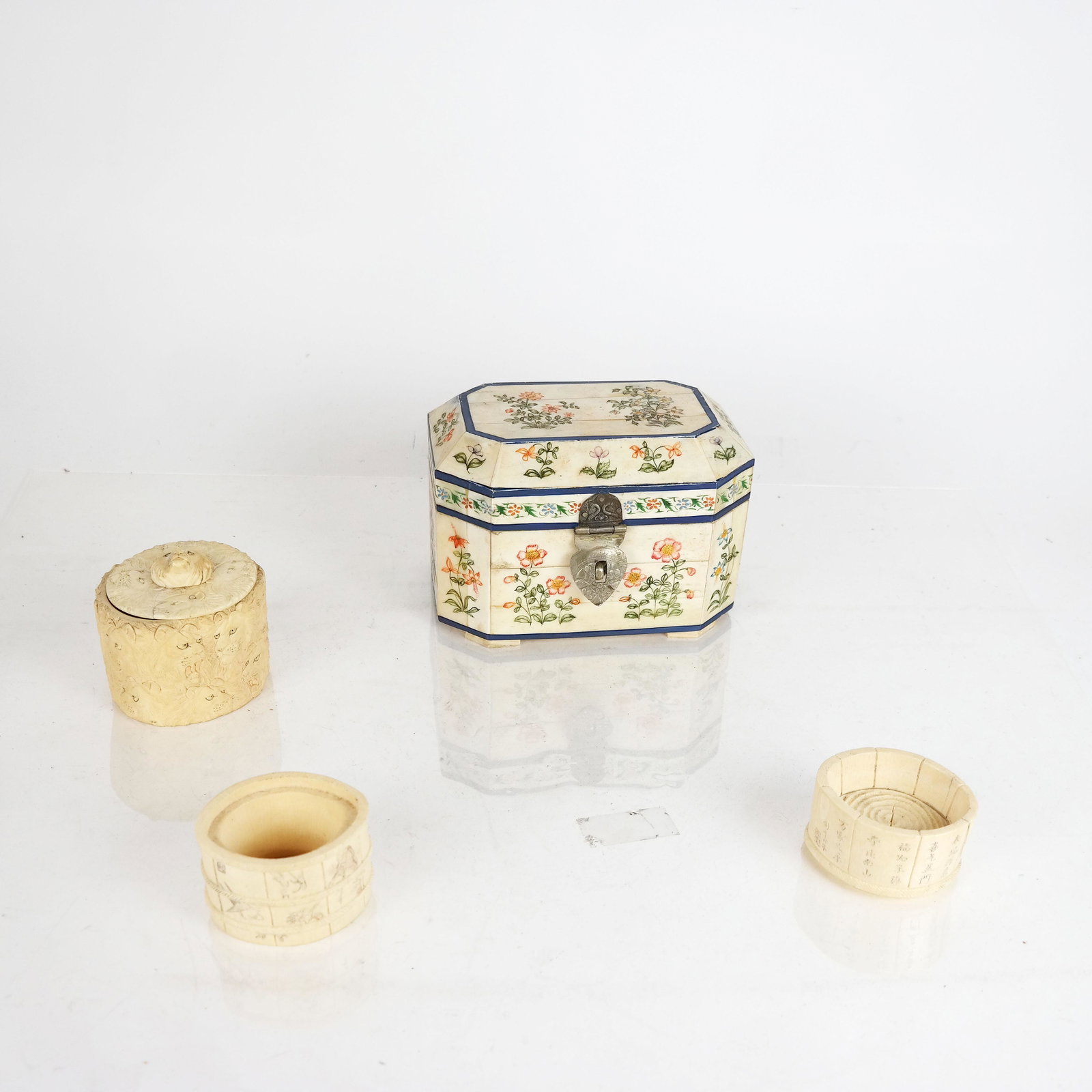 Chinese Scrimshaw Containers & Others: Group of four boxes, including two scrimshaw decorated bone boxes, a small bone box and a carved lion relief bone box. Provenance: From the Upper East Side estate of a prominent NYC interior decorator