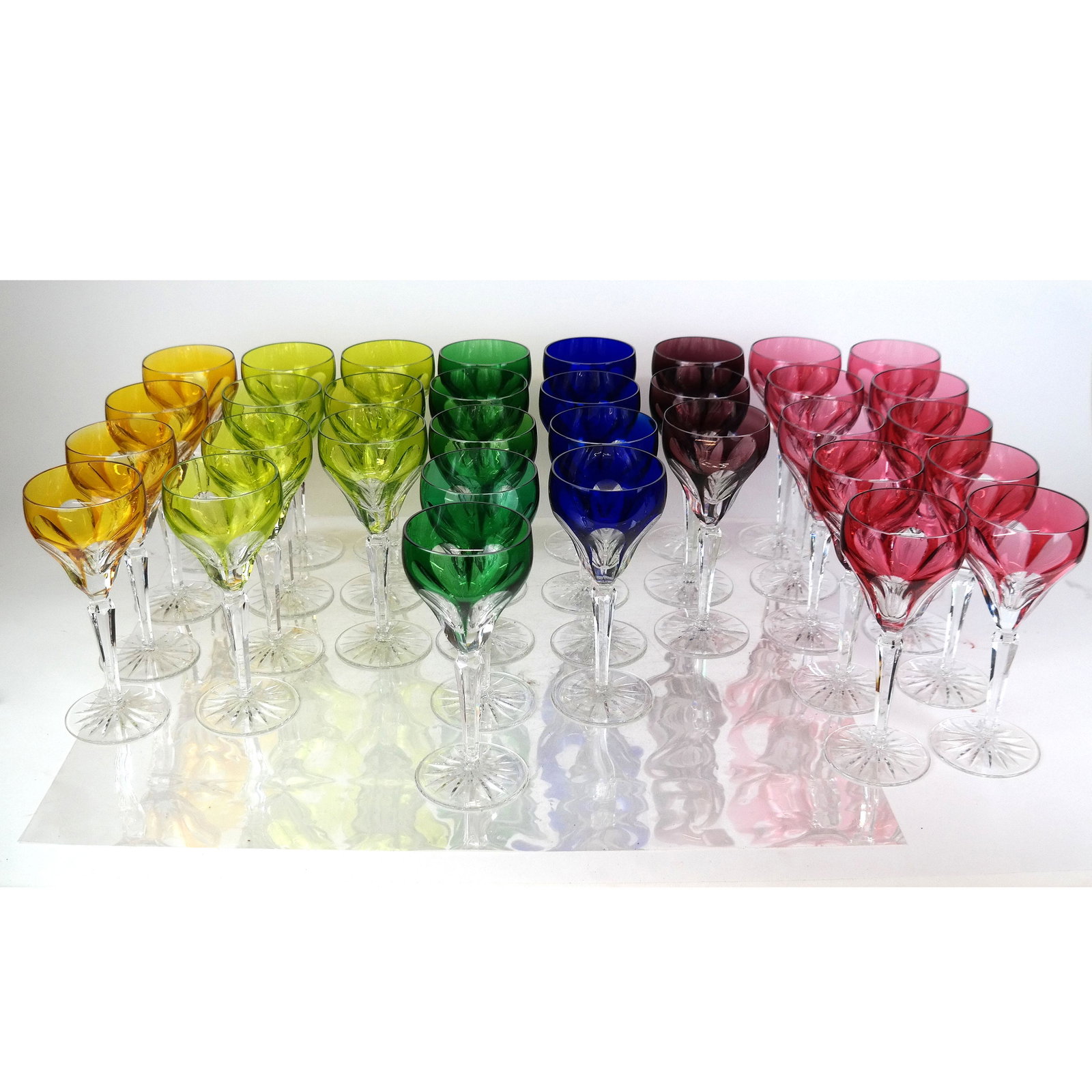 Set of 33 Bohemian Glass 8" Goblets: Set of Bohemian crystal wine glasses / goblets, in an assortment of jewel colors, having cut crystal bases and thumb print cups. [8" H]. In good condition; no chips.
