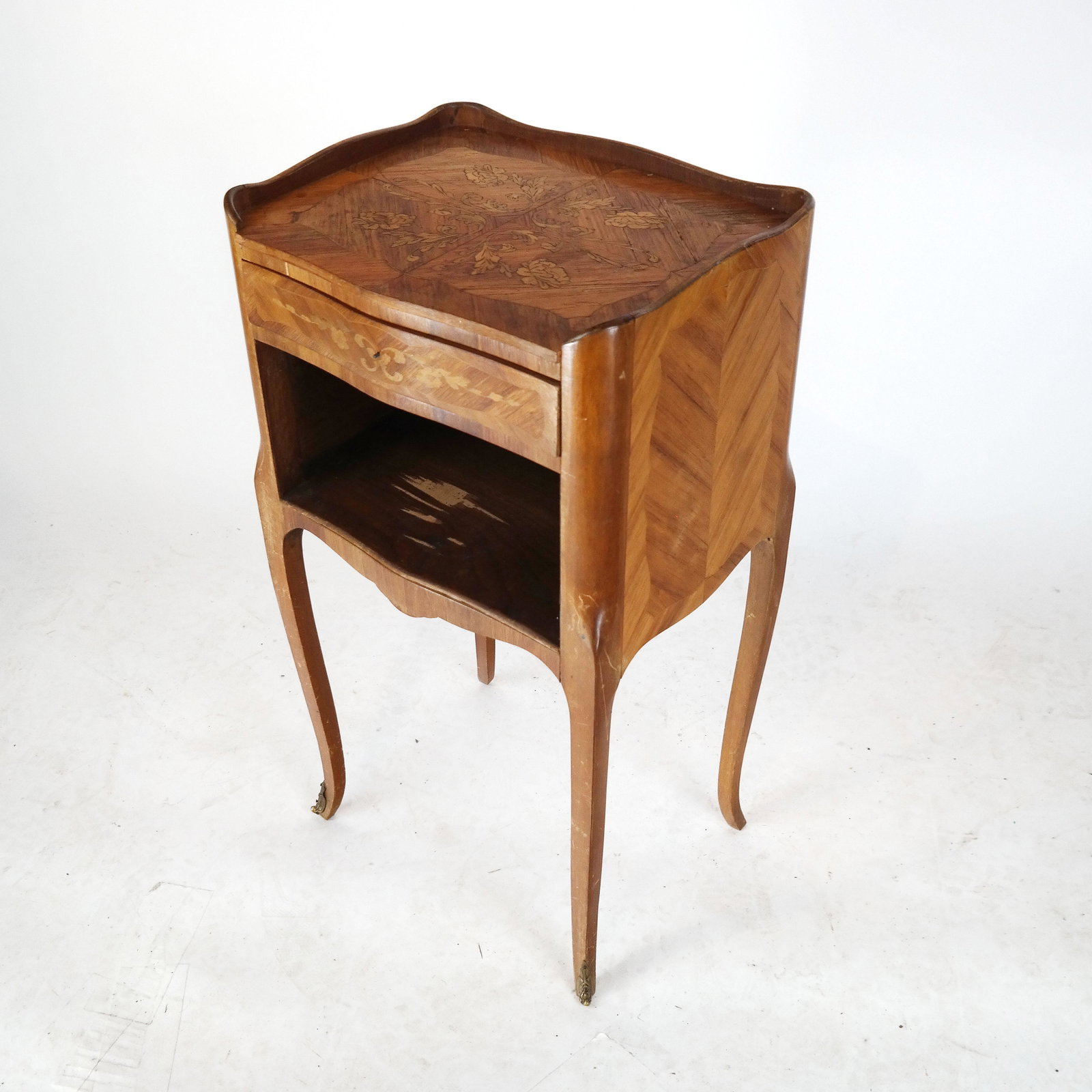 Inlaid Marquetry Night Stand: Inlaid marquetry night stand, the rectangular top over a single drawer, raised on bronze mounted cabriole legs. [29 1/2" H x 15 1/2" W x 12" D]. Drawer missing knob; wear and losses to veneer.