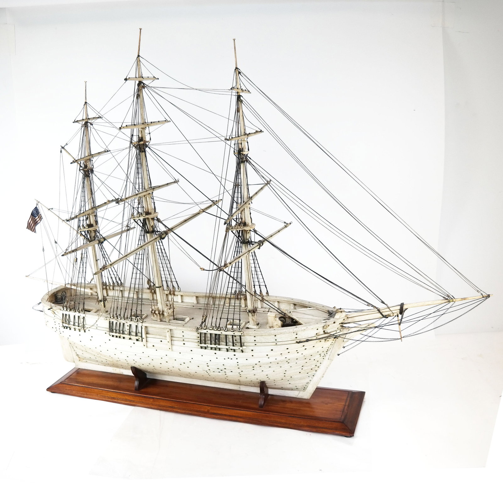 Monumental Carved Bone Ship Model: Antique American whalebone ship model (circa 1850-60) of a three-masted merchant ship of the type that was used to transport materials from New England ports up and down the East Coast to Florida and 