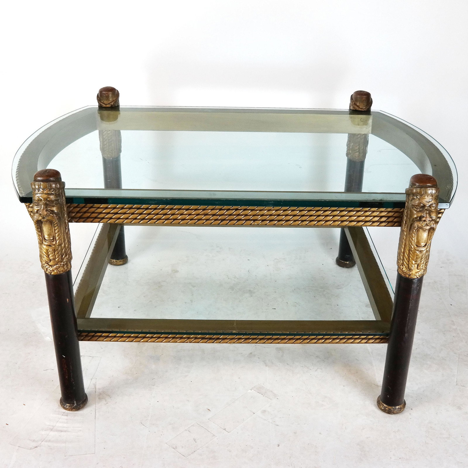 Parcel Gilt Carved Wood & Glass Coffee Table: Carved and parcel gilt wood coffee table with two plate glass inset shelves, the posts (possibly re-purposed from an earlier piece) in the form of a bearded man. [25 1/2" H x 45" W x 35" D]. Wear and 