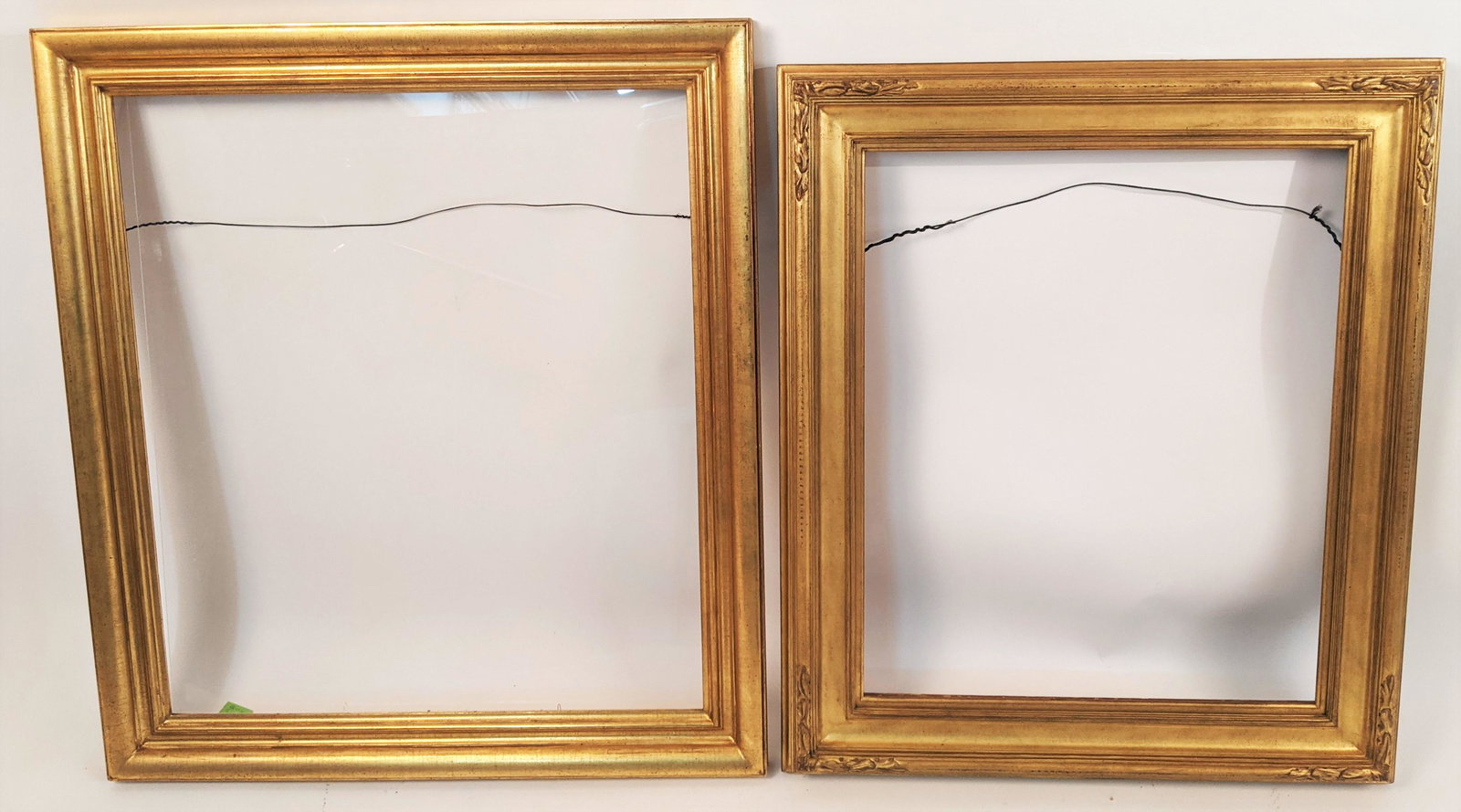 Two Gilt Frames: Two wood gilt frames, one with plexiglass. [Outside: 29 1/2" H x 34 3/8" W; Rabbet: 22 3/8" H x 27 1/4" W; Outside: 32 1/2" H x 36 3/4" W; Rabbet: 26 7/8" H x 30 3/4" W]. In good condition.