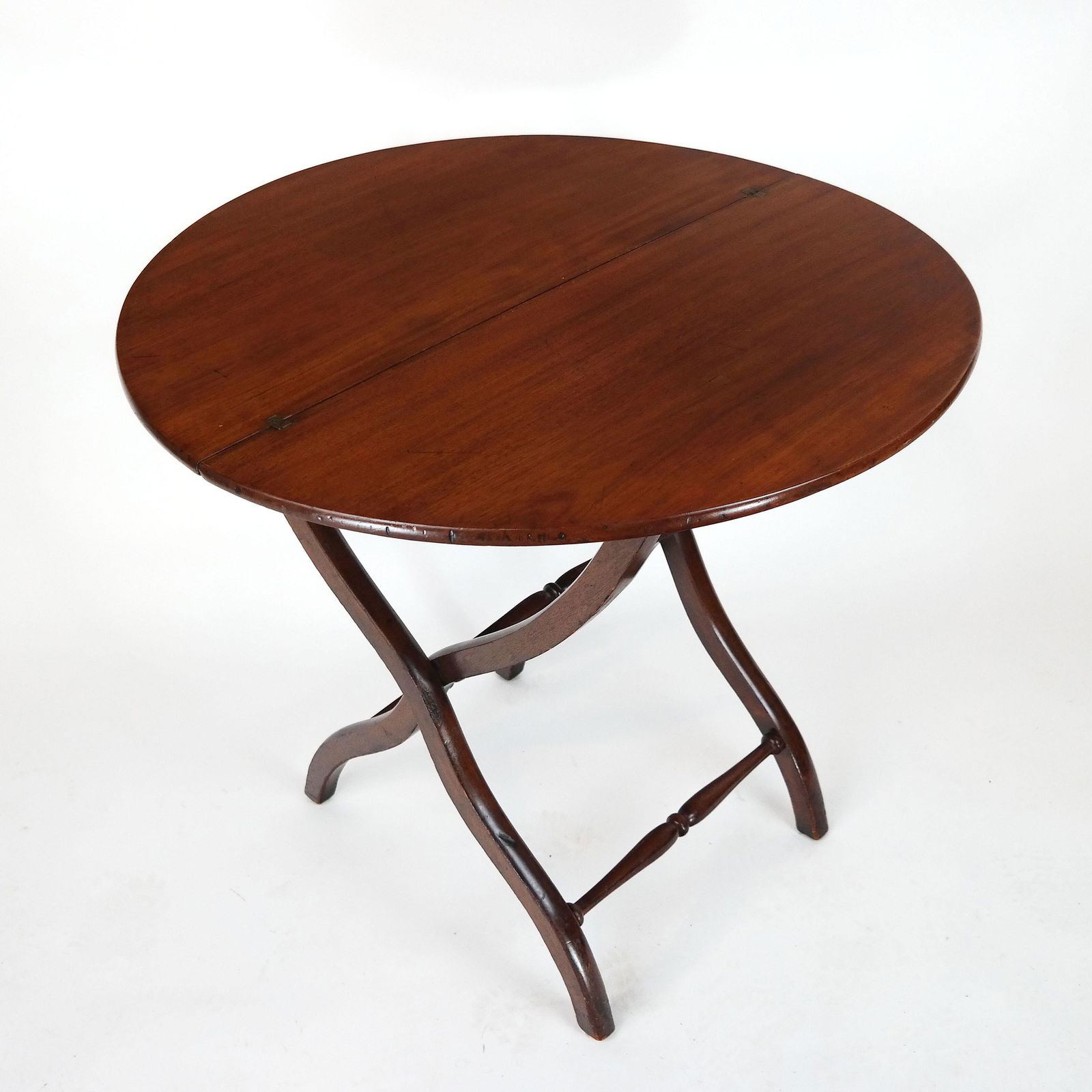 Antique English Folding Wine Table: Mahogany table, on spindle stretchers, with a locking top. [Top open: 29" H x 32" Diam.].