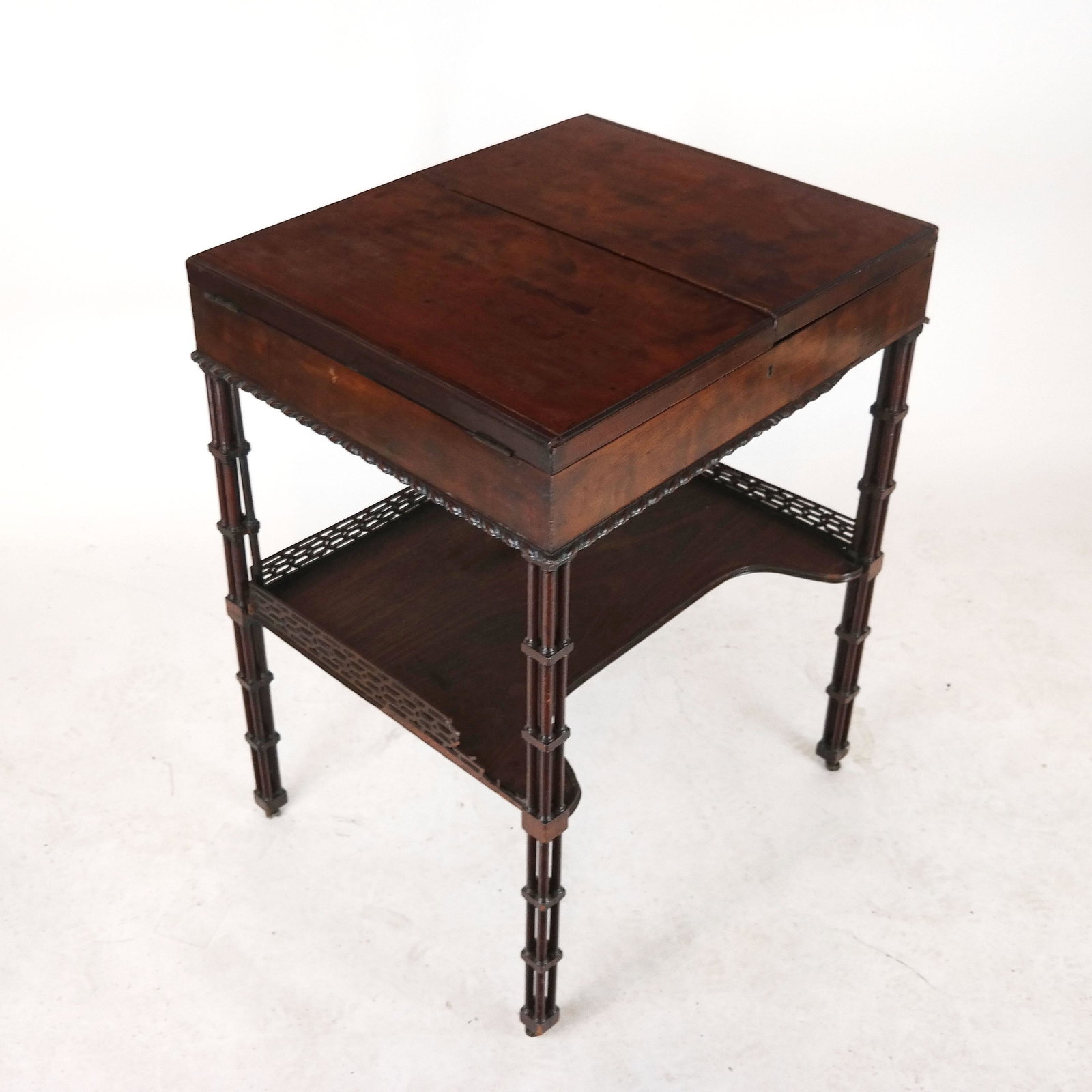 George III Period Desk Cabinet / Beau Brummell: George III period mahogany fold out top cabinet, circa 1790, with fitted interior and lift-up mirror, on quad post legs, with concave lower tier. [31" H x 24" W x 20" D]. Many splits and damages.