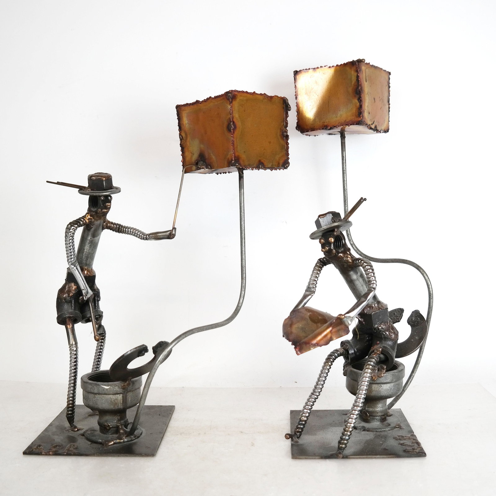 Pair of Industrial-Style Sculptures, as Lamps: Matched pair of whimsical industrial sculpture, made of bolts and found items, depicting men in a restroom, with votive holders, mounted as lamps. Signed, “ASR”; 20th century, American. [18" H x 1