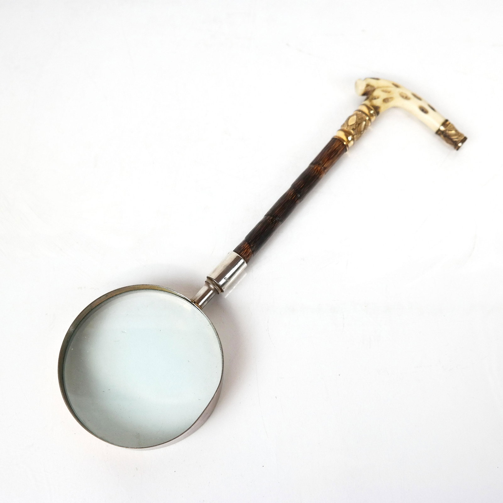 Carved Bone and Brass Magnifying Glass: Magnifying glass with carved bone and ornate brass handle. [11 3/4" L]. In good condition.
