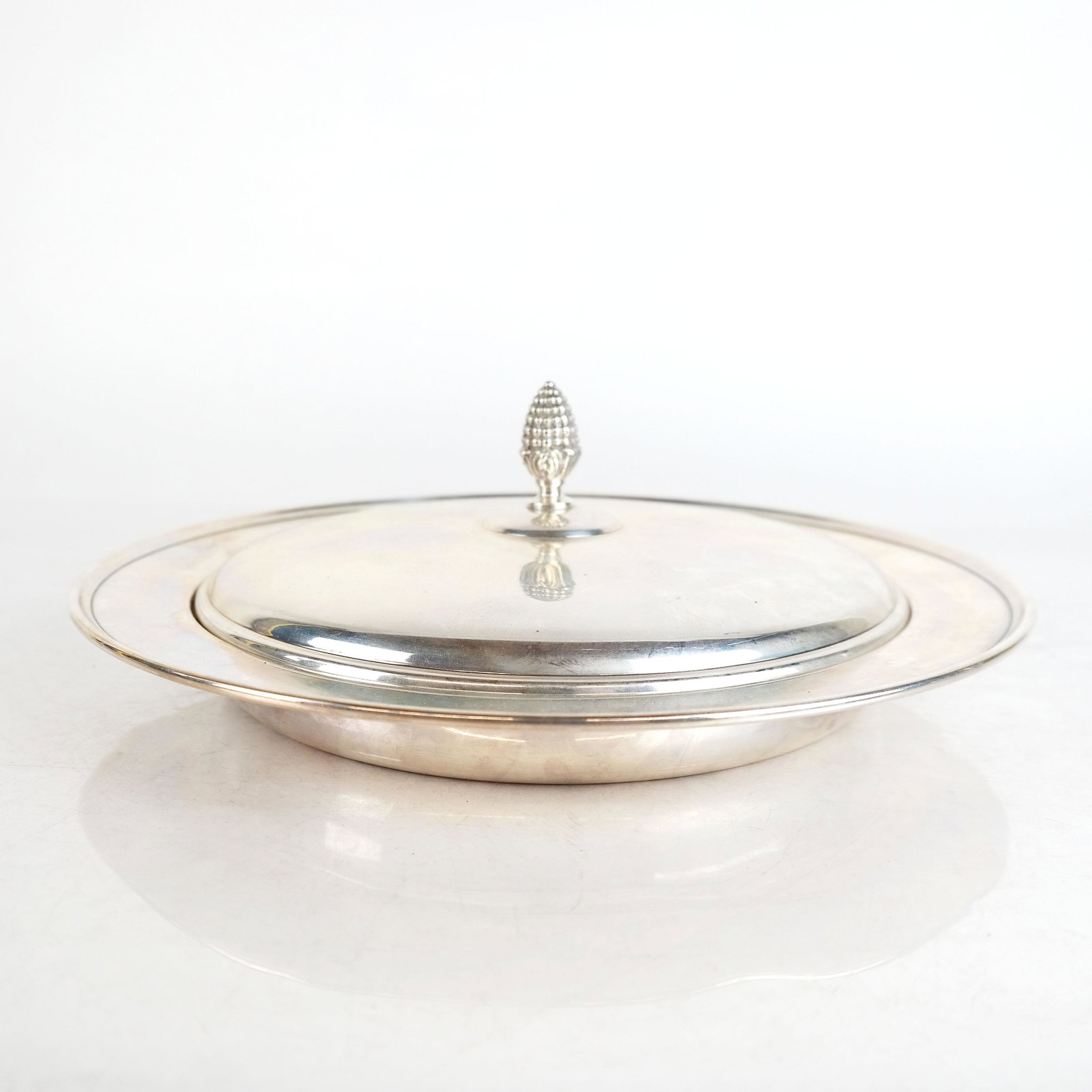 Bailey, Banks & Biddle Sterling Tureen: Sterling silver covered shallow tureen with pineapple finial cover. 27.2 ozt. [4" H (to finial) x 12" Diam.]. In good condition.