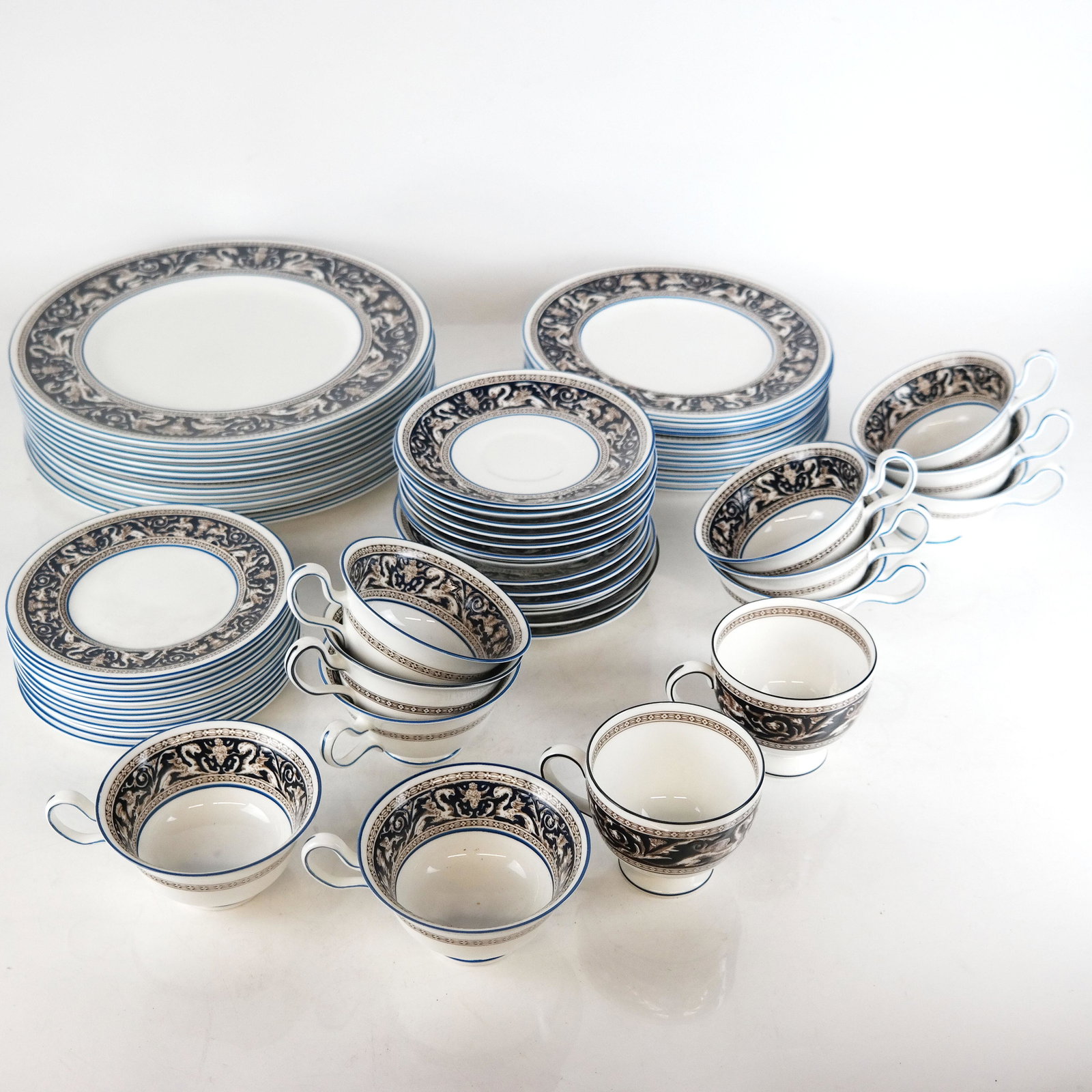 Wedgwood "Florentine" Bone China Dinnerware: 61 pieces of Wedgwood Florentine blue bone china, including 12 dinner plates [10 5/8" ], 12 salad plates [8"], 12 bread and butter plates [6"], 11 cups [2 1/4"H x 4" Diam.], 12 saucers [5 3/4"] and 2 