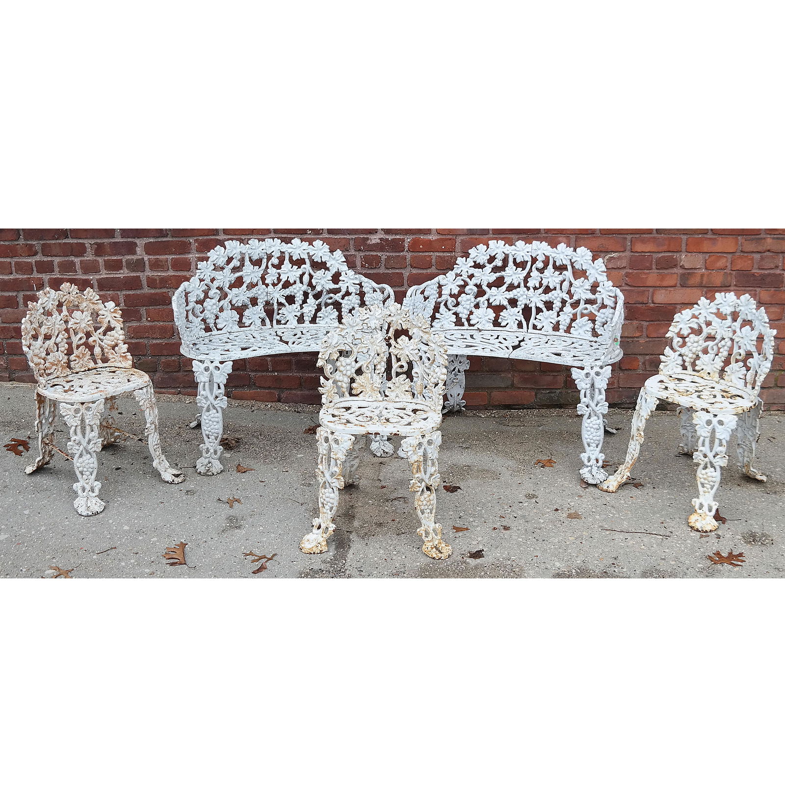 Vintage Cast Iron 5-Piece Set: Outdoor set comprised of 2 settees and 3 chairs, in grape and vine motif. [Settees: 29" H x 32" W x 15" D; Chairs: 27" H x 16" W x 12" D].