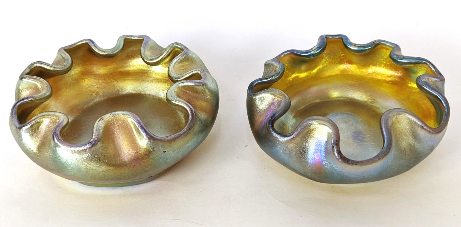 Pair of Louis Comfort Tiffany Finger Bowls / Salts: Pair of Louis Comfort Tiffany favrile glass finger bowls / salts. Signed L.C.T. From the Estate of June Hirsch Jones. [1 1/4" H x 2 1/2" W]. In good condition.