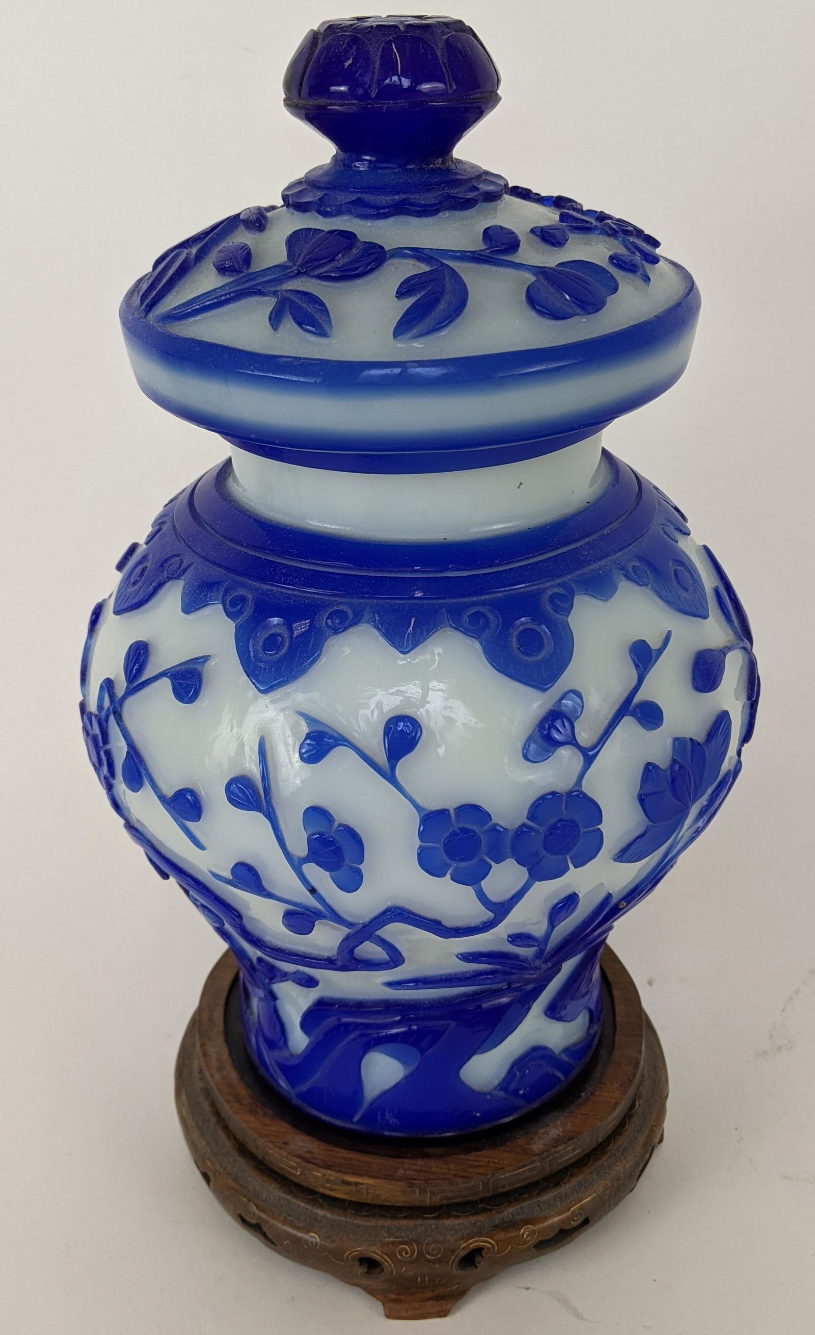Blue Peking Glass Covered Jar: Blue on white Peking glass covered jar, floral decorated. From the Estate of June Hirsch Jones. [9 3/4" H x 5 1/2" D]. Rim chip.