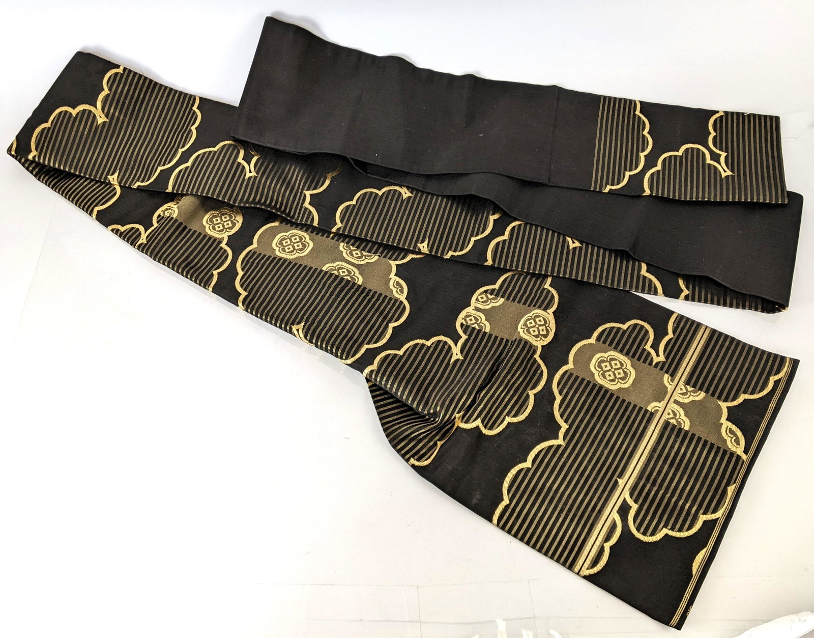 Japanese Black & Gold Silk Obi: Japanese black and gold silk embroidered obi. From the Estate of June Hirsch Jones. [12 3/4" H (at widest) x 13" W x 6" D]. In good condition.