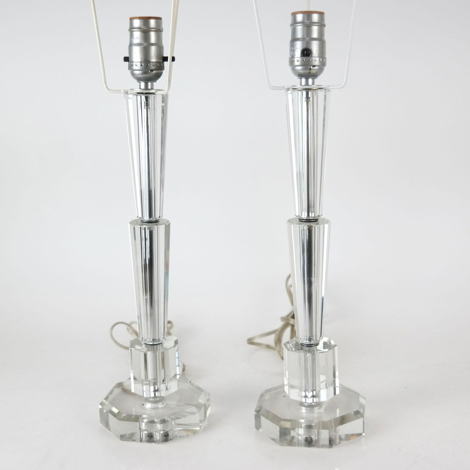 Pair of Clear Lucite Desk / Table Lamps: Pair of clear lucite desk / table lamps. From the Estate of June Hirsch Jones. [21" H x 4 1/2" Diam. (base)]. Harps present, but no shades. In good condition.