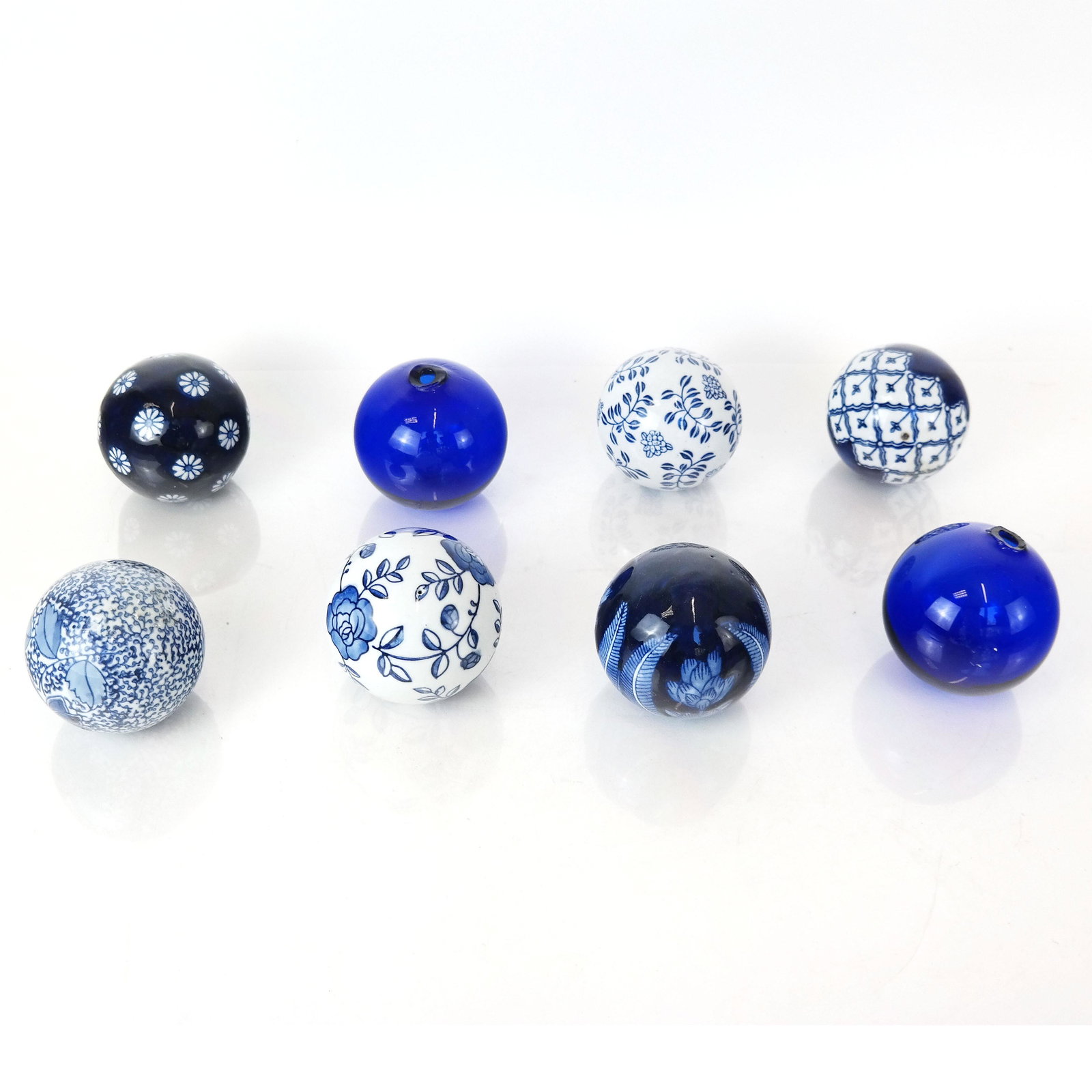 Lot of Eight Porcelain and Glass Balls: Group comprises six Chinese blue and white porcelain balls, and a pair of blue glass balls, all modern. From the Estate of June Hirsch Jones. [3" Diam.]. In good condition.