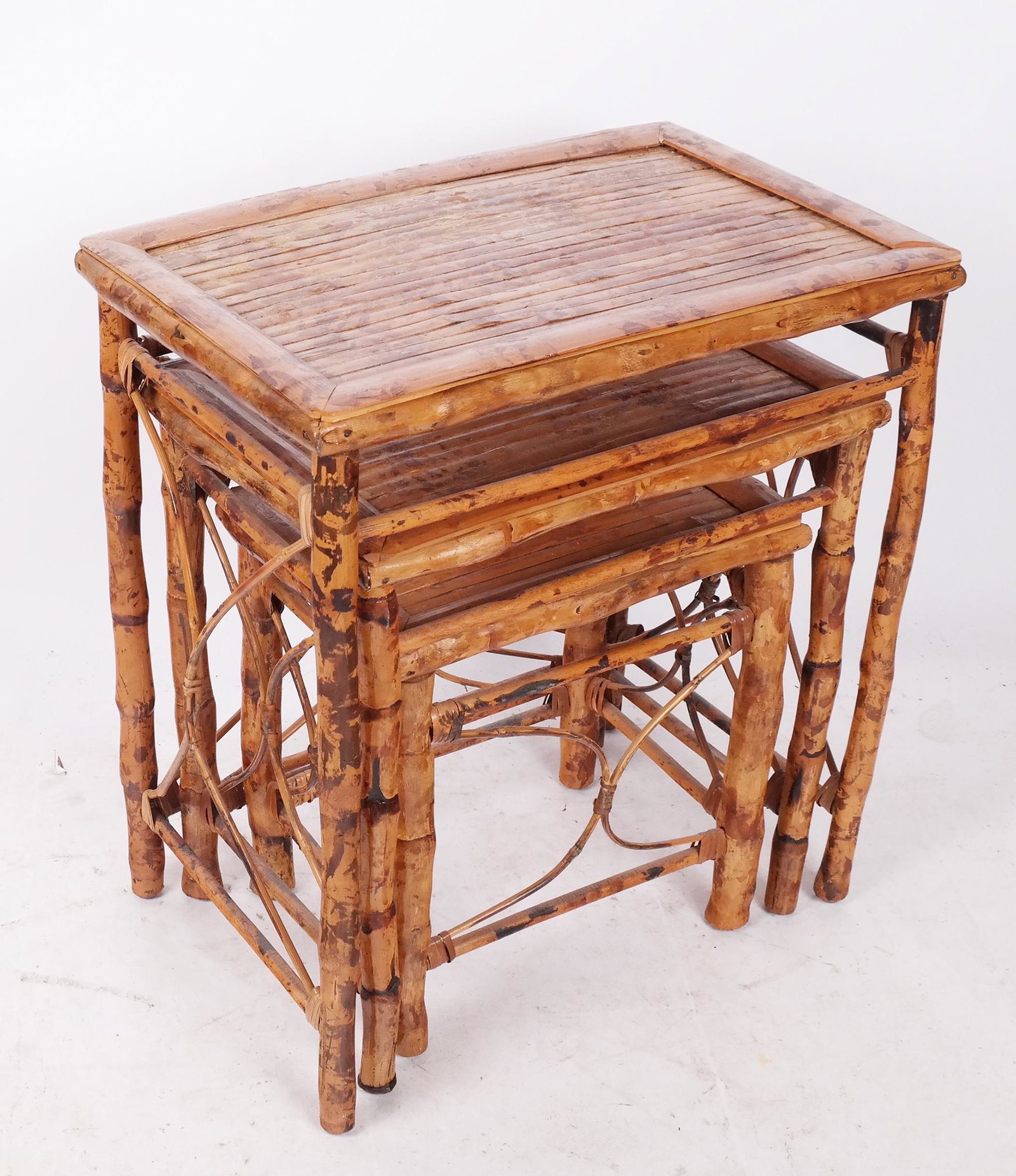 Nest of Three Rattan Tables: Nest of three rattan tables, bamboo legs. From the Estate of June Hirsch Jones. [27" H x 24" W x 16" D]. In good condition.