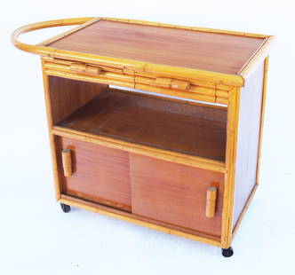 Vintage Paul Frankl-Style Rattan Rolling Cart: Mid-century Paul Frankl-style rattan rolling cart, having two top drawers over a shelf above a two-door storage area. [30" H x 42' W x 20 1/2" D]. Drawers sticky; doors stuck.