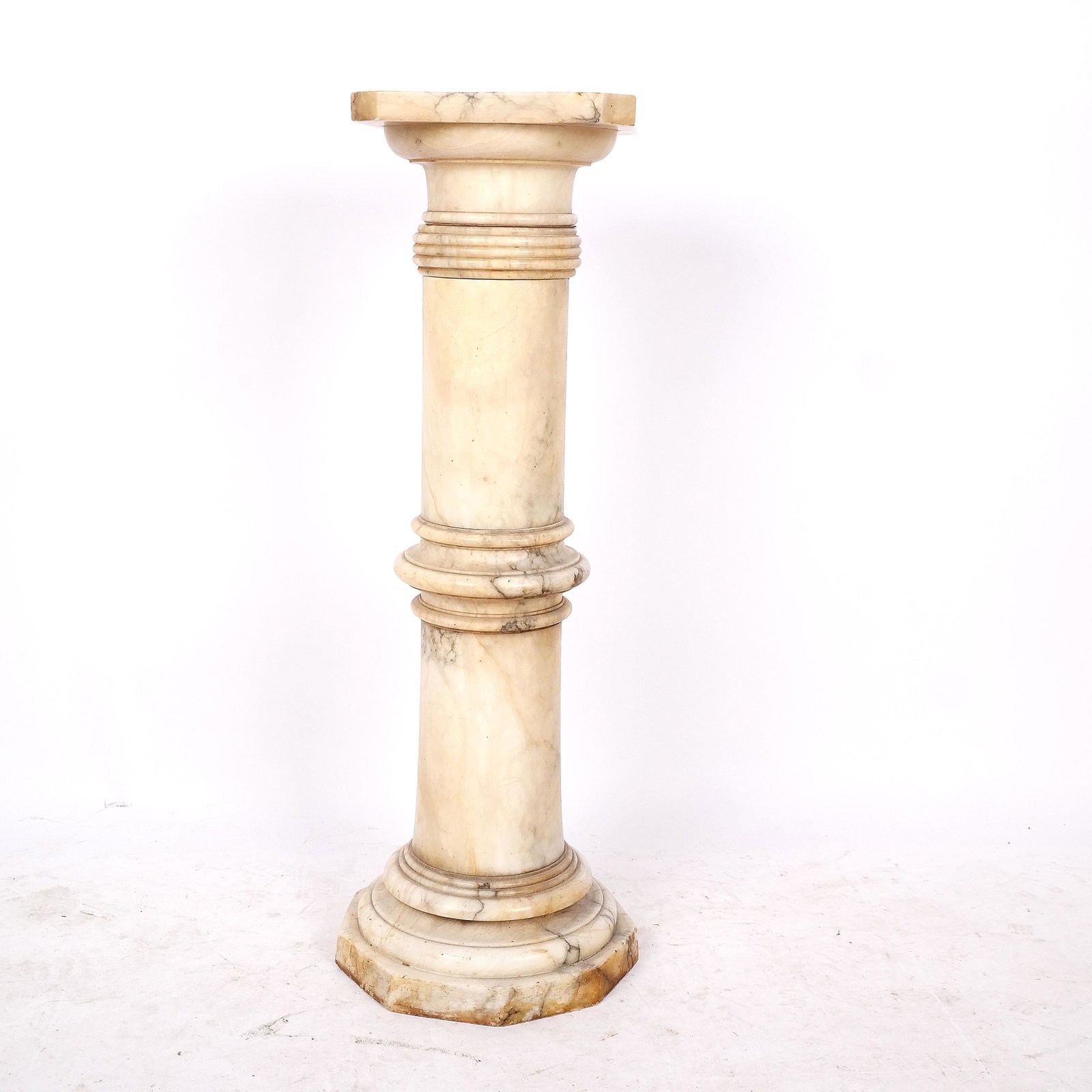 Classical-Style Alabaster Pedestal: Classical-style alabaster pedestal, with octagonal top on round columnar and collared post, with nine sided base. [36" H x 13" Diam.].