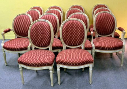 Fourteen Louis XVI Style Chairs: A creme and white painted set of French dining room chairs, consisting of two arm and twelve side chairs. Red & cremem= upholstery, round backs. 36.5" H (backs) x 17.75" H (to seat) x 16" to 21.5" W (